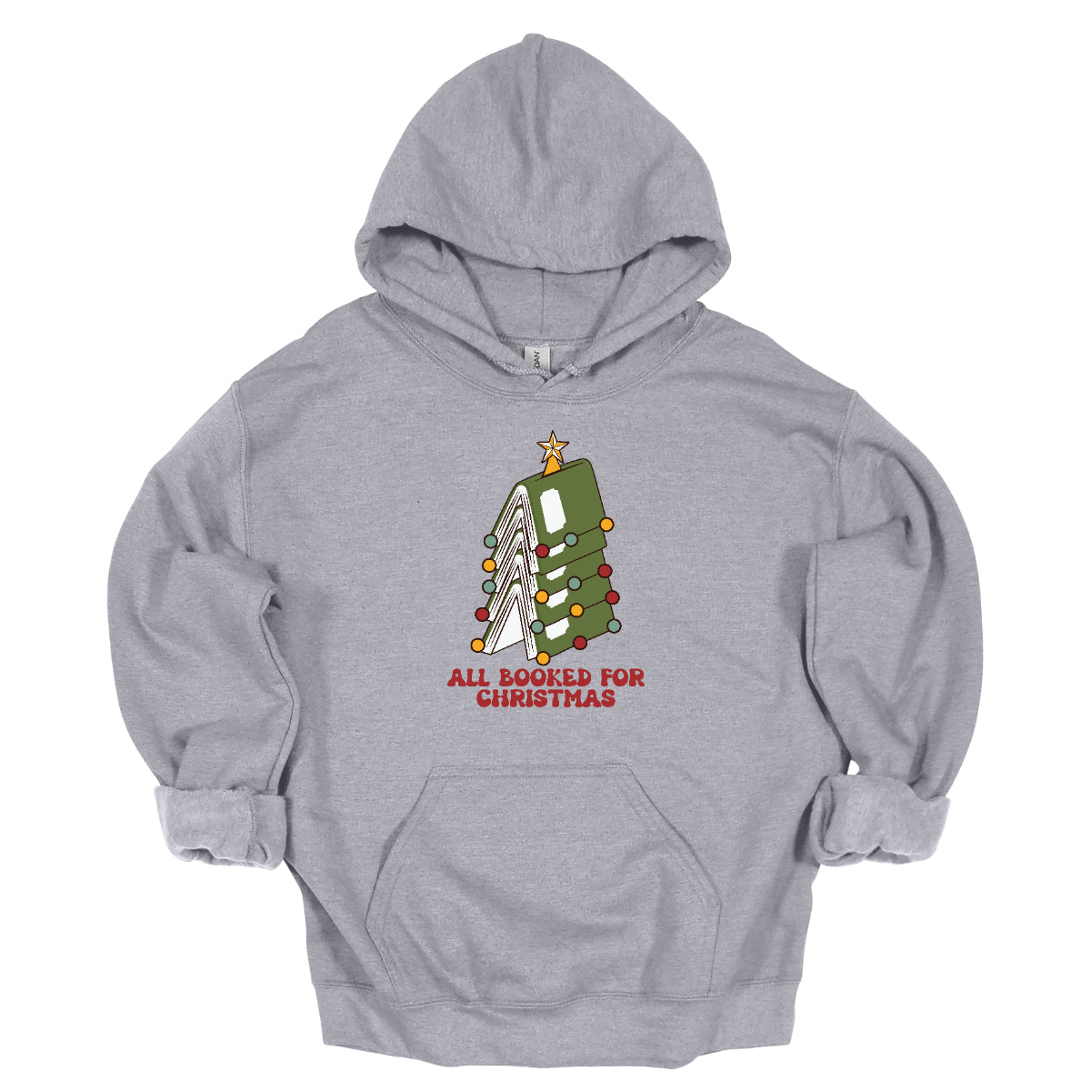 This whimsical t-shirt features the playful phrase "All Booked for Christmas" in a bold, red bubbly font that captures the festive spirit. Above the text, a delightful image showcases a stack of green books, artfully arranged to resemble a decorated Christmas tree. Shop Gorgeousware.com