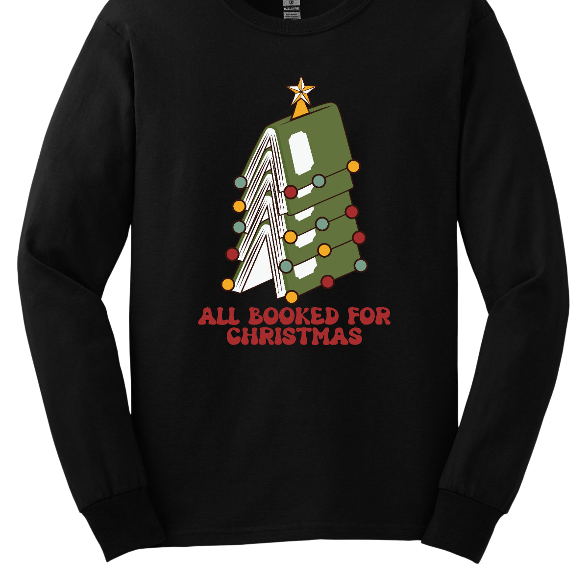 This whimsical t-shirt features the playful phrase "All Booked for Christmas" in a bold, red bubbly font that captures the festive spirit. Above the text, a delightful image showcases a stack of green books, artfully arranged to resemble a decorated Christmas tree. Shop Gorgeousware.com