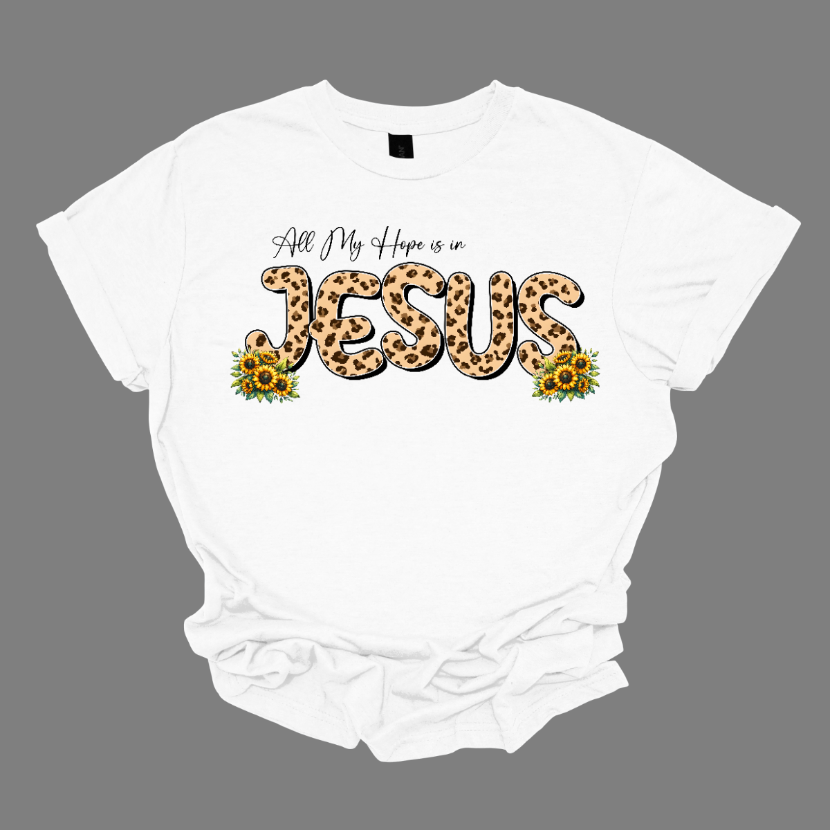 This shirt features the uplifting phrase "All My Hope is in Jesus" in a beautiful design. The text is written in elegant black script, with the word "Jesus" standing out in bold, bubble script, filled with a trendy animal print pattern in the middle. Surrounding the lettering are delicate, colorful flowers that frame the message, adding a touch of nature's beauty to the design. Shop Gorgeousware.com