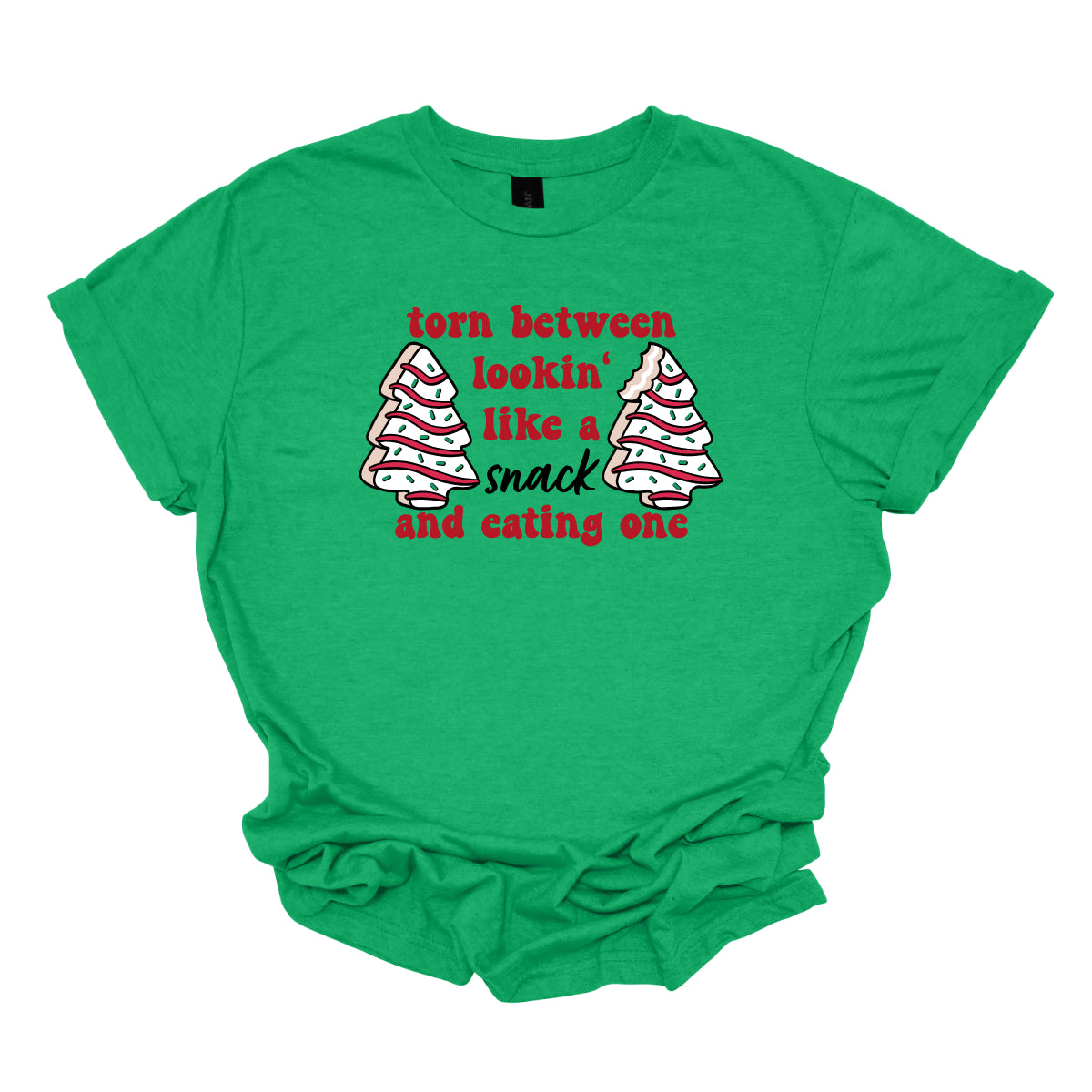 This fun t-shirt features the playful phrase "Torn between lookin' like a snack and eating one" in a vibrant red bubbly font, adding a lively and festive touch. The word "snack" stands out in an elegant black cursive font, creating a nice contrast. Flanking the text are adorable illustrations of Christmas tree cakes on each side, enhancing the holiday spirit and adding a whimsical flair. This shirt is perfect for anyone who loves to celebrate the season with humor and style! Shop Gorgeousware.com