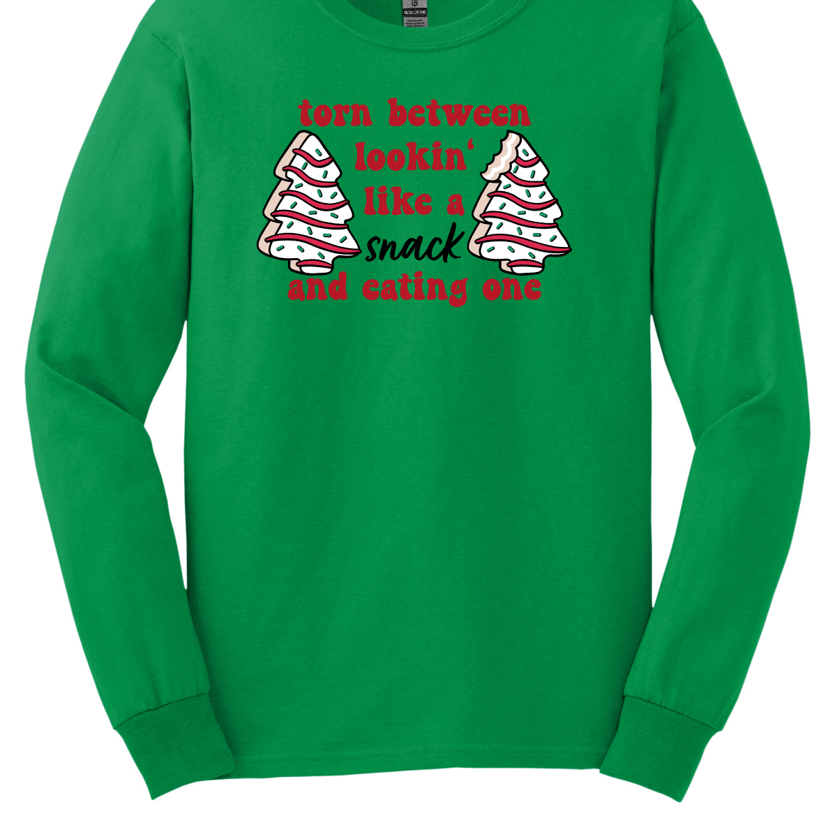 This fun t-shirt features the playful phrase "Torn between lookin' like a snack and eating one" in a vibrant red bubbly font, adding a lively and festive touch. The word "snack" stands out in an elegant black cursive font, creating a nice contrast. Flanking the text are adorable illustrations of Christmas tree cakes on each side, enhancing the holiday spirit and adding a whimsical flair. This shirt is perfect for anyone who loves to celebrate the season with humor and style! Shop Gorgeousware.com