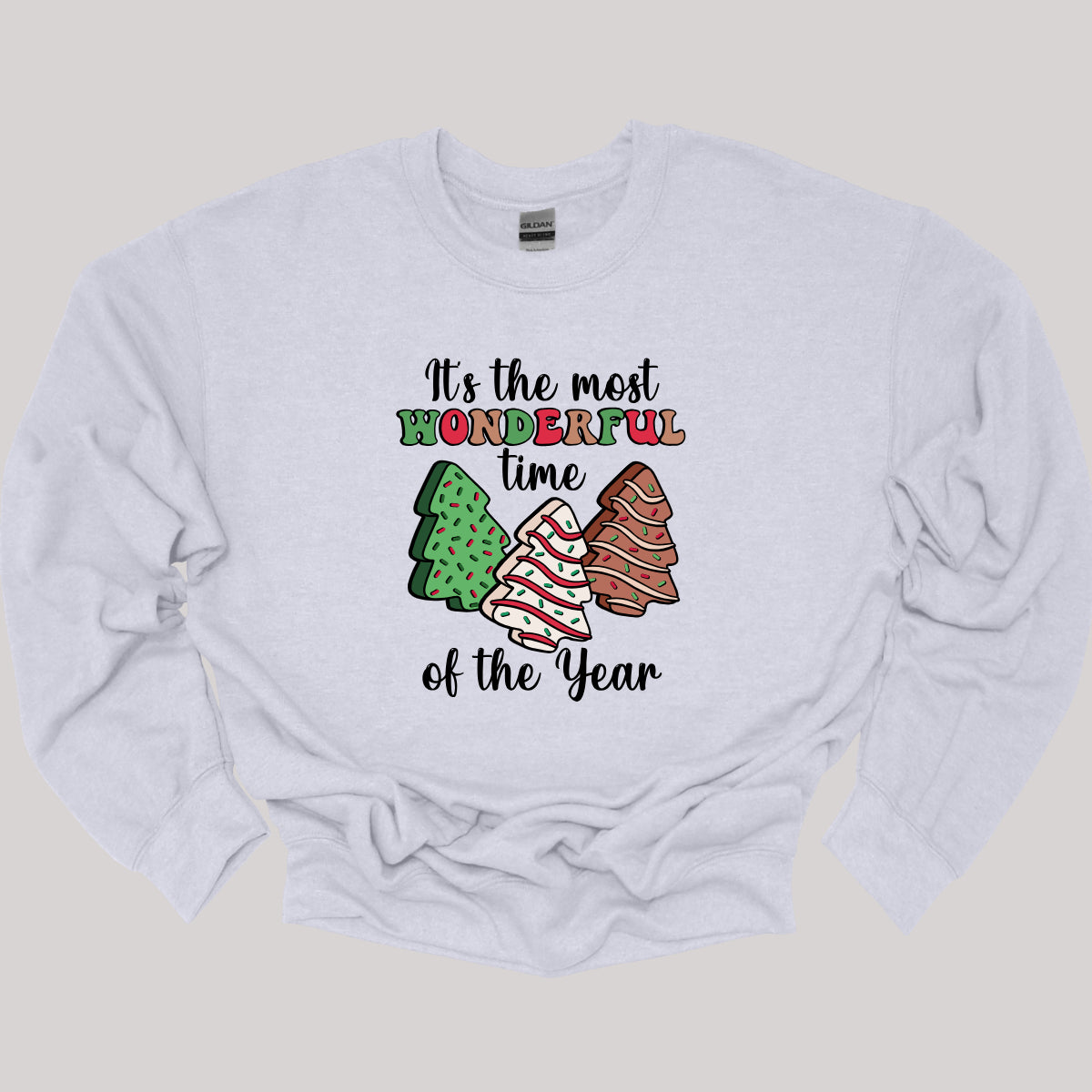 This festive t-shirt features the phrase "It's the most wonderful time of the year" in a stylish black cursive font, creating an elegant backdrop for the holiday message. The word "wonderful" stands out in a playful bubbly font that alternates between vibrant green, cheerful red, and warm brown, adding a whimsical touch. Shop Gorgeousware.com