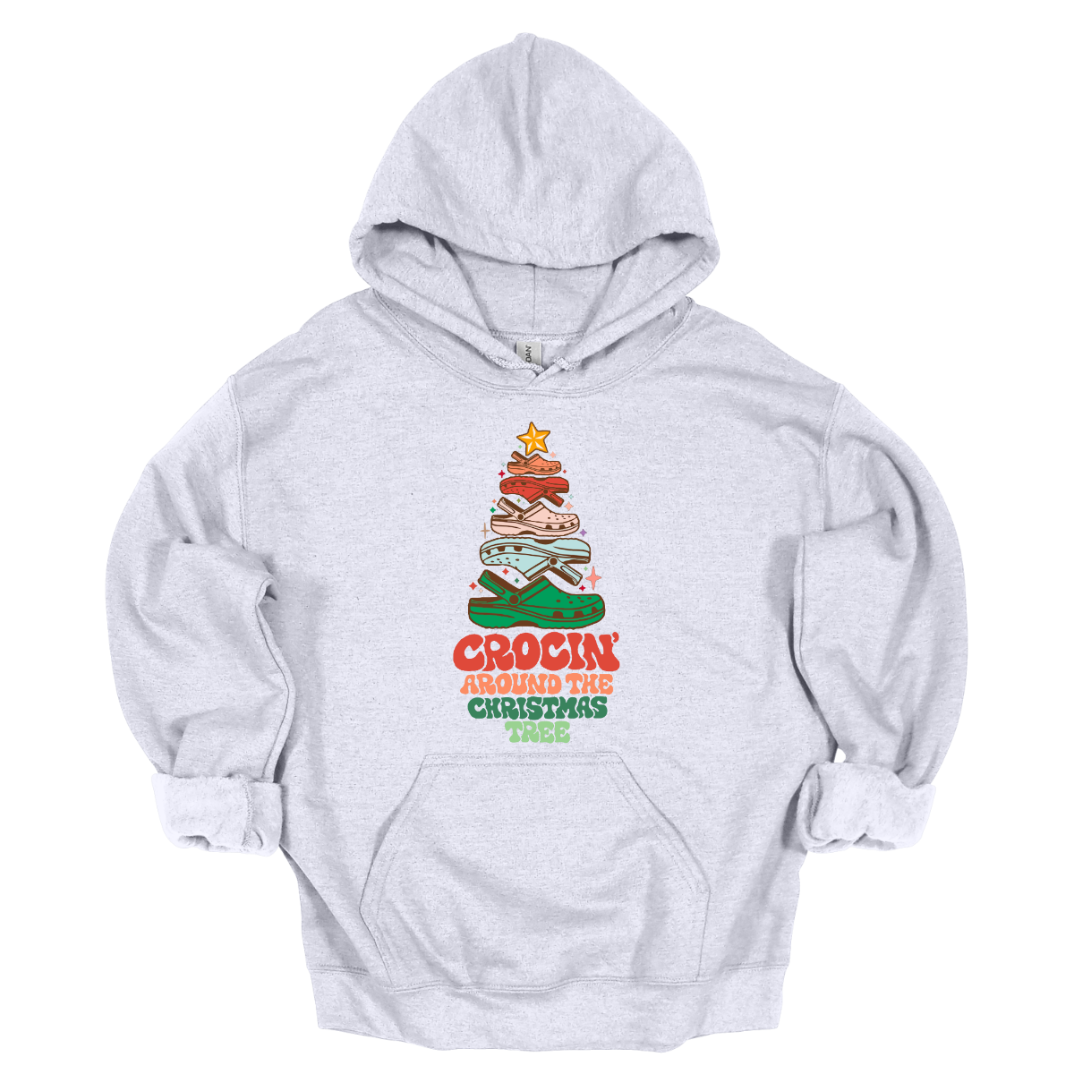 This fun t-shirt features the playful phrase "Crockin' Around the Christmas Tree" in a retro-inspired font that combines vibrant reds and greens for a festive touch. The centerpiece of the design is a whimsical Christmas tree crafted entirely from colorful croc shoes, stacked creatively to form the classic shape. Topping off the tree is a shiny star, adding a delightful finishing touch. Shop at Gorgeousware.com
