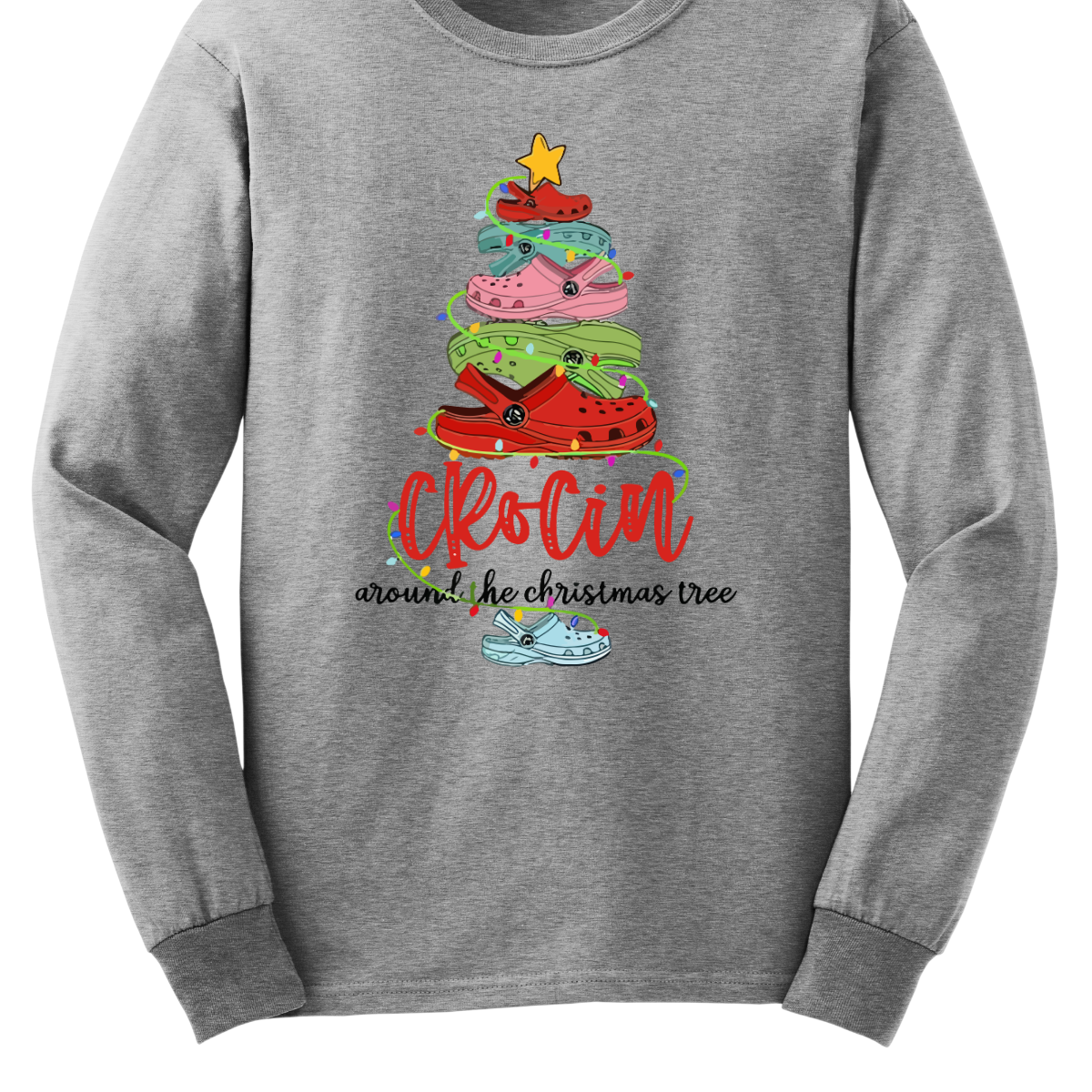 This playful t-shirt features the fun phrase "Crockin' Around the Christmas Tree" with a unique twist. The word "Crockin'" is showcased in a vibrant red cursive font, with playful spaces between the letters, adding a whimsical flair. Below that, the rest of the phrase is written in a smaller, elegant black cursive font, providing a charming contrast. Shop Gorgeousware.com