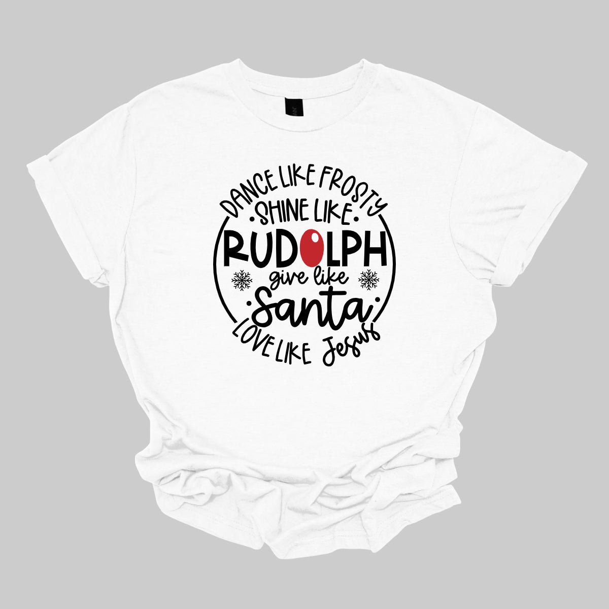 This heartwarming t-shirt features the uplifting phrase "Dance like Frosty, shine like Rudolph, give like Santa, love like Jesus" arranged in an array of stylish black fonts that create a dynamic and eye-catching design. The “O” in "Rudolph" is playfully highlighted in red, resembling his famous nose, adding a festive touch to the overall look. Shop Gorgeousware.com