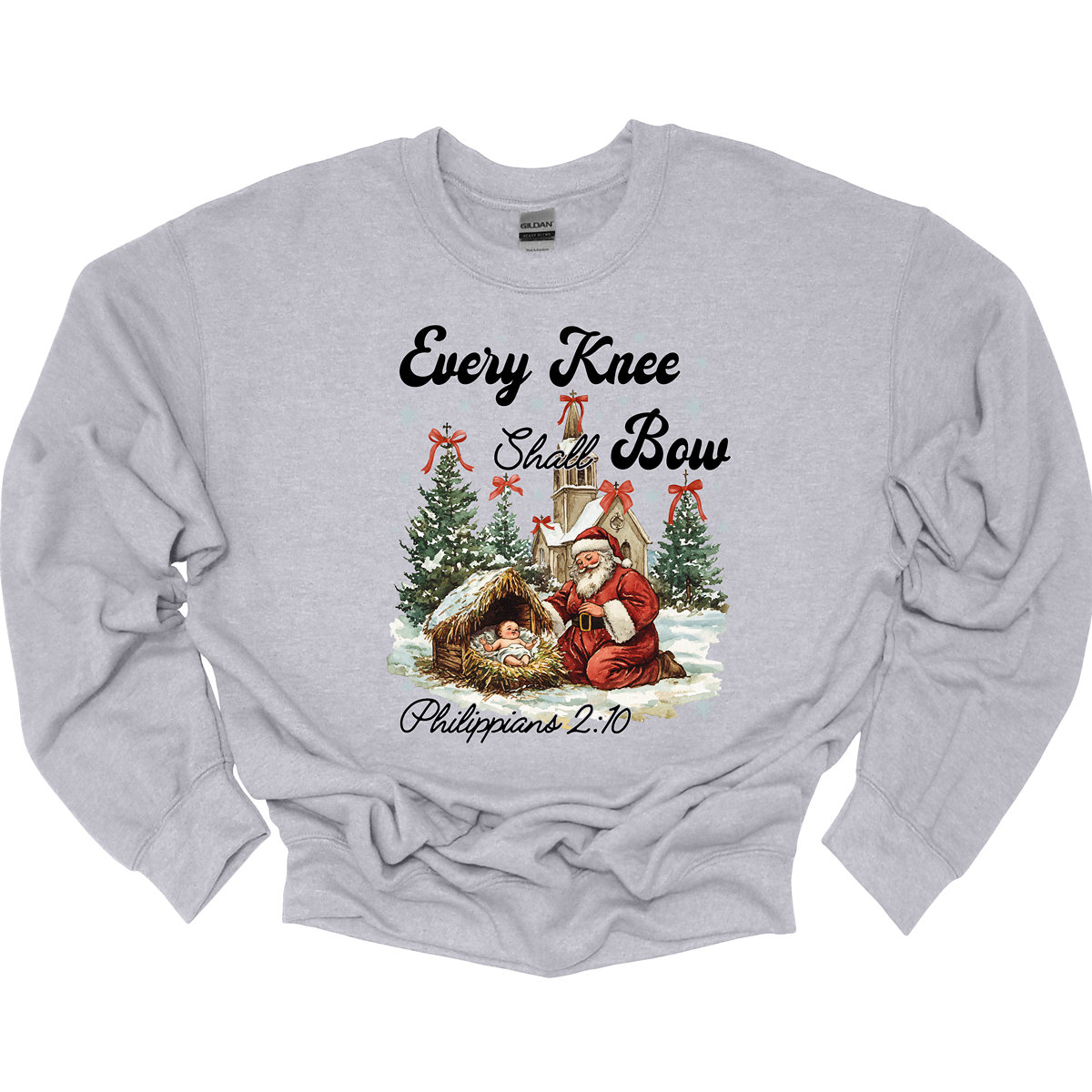 This festive and powerful apparel design features the phrase "Every Knee Shall Bow" in bold, elegant lettering, symbolizing the reverence and humility of the Christmas story. The artwork showcases Santa Claus, traditionally known for his joyful spirit, bowing down in awe before a humble manger that cradles baby Jesus. In the background, an old chapel stands as a symbol of faith, with evergreen trees adorned with festive bows, adding a touch of seasonal beauty and serenity. Shop at Gorgeousware.com