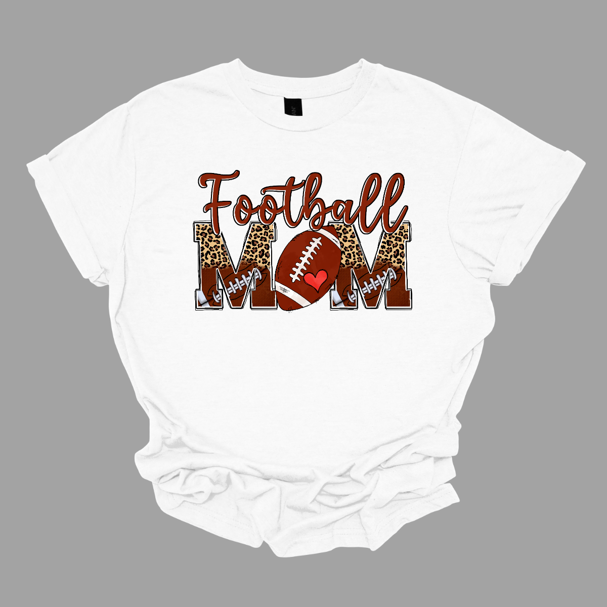 This "Football Mom" shirt design features a stylish and bold look perfect for any proud football mom.
"Football" is written in a fun, flowing brown script. "MOM" is displayed in large split block letters, The top half of the letters showcases a trendy cheetah print, adding a touch of fierce and fashionable flair.
The bottom half is decorated with a pattern of small footballs. The "O" in "MOM" is creatively replaced with a football. Shop Gorgeousware.com
