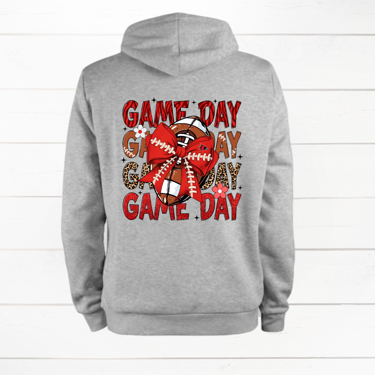 This bold SEMO shirt packs serious team spirit into every detail. The front has a ferocious Redhawk graphic paired with SEMO in bold white lettering over the left chest. The back has “Game Day” repeated in eye catching animal print and football-lace lettering. A football wrapped in a red bow steals the spotlight, complete with football-lace details and a small Redhawk perched on the bow. Go Redhawks!
Shop at Gorgeousware.com today!