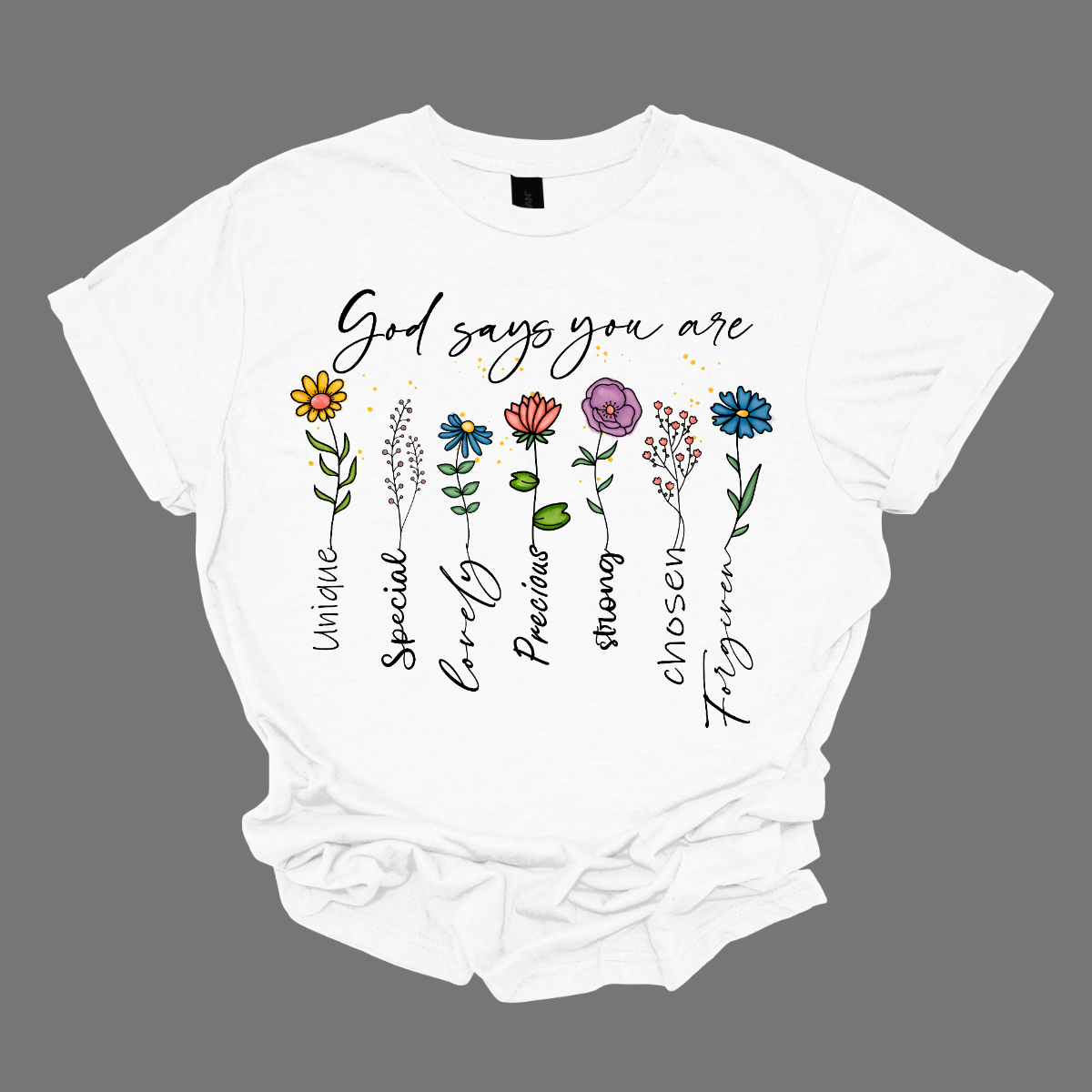 Divine Blooms T-shirt, a vibrant fusion of faith, affirmation, and floral beauty! Embrace the powerful message of divine love and empowerment with this stunning design, featuring colorful flowers blooming from the uplifting words: "God says you are unique, special, loved, precious, strong, chosen, forgiven." Each stem of this floral masterpiece represents a facet of your divine identity, reminding you of your inherent worth and the boundless love that surrounds you. Shop now at Gorgeousware.com