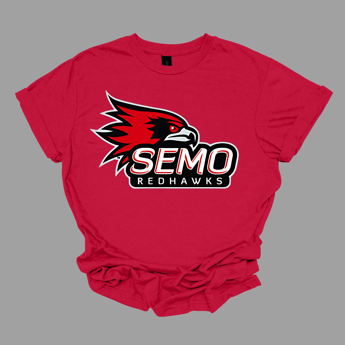 This vibrant t-shirt features the iconic SEMO Redhawk logo prominently displayed at the top, showcasing the fierce spirit of the team. Below the hawk, bold bubble letters spell out "SEMO," creating a playful and eye-catching design. Just underneath, in smaller, stylish print, the word "Redhawks" completes the look, making it a perfect blend of fun and team pride. Shop at Gorgeousware.com