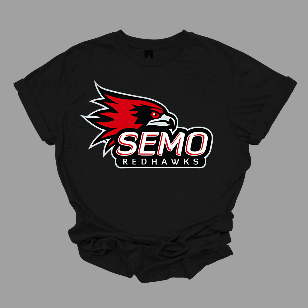 This vibrant t-shirt features the iconic SEMO Redhawk logo prominently displayed at the top, showcasing the fierce spirit of the team. Below the hawk, bold bubble letters spell out "SEMO," creating a playful and eye-catching design. Just underneath, in smaller, stylish print, the word "Redhawks" completes the look, making it a perfect blend of fun and team pride. Shop at Gorgeousware.com