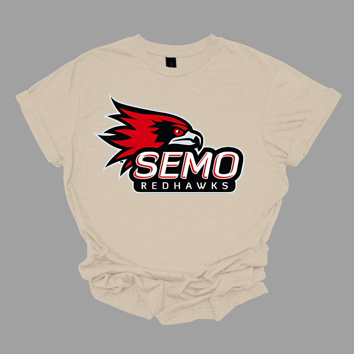 This vibrant t-shirt features the iconic SEMO Redhawk logo prominently displayed at the top, showcasing the fierce spirit of the team. Below the hawk, bold bubble letters spell out "SEMO," creating a playful and eye-catching design. Just underneath, in smaller, stylish print, the word "Redhawks" completes the look, making it a perfect blend of fun and team pride.  Shop at Gorgeousware.com