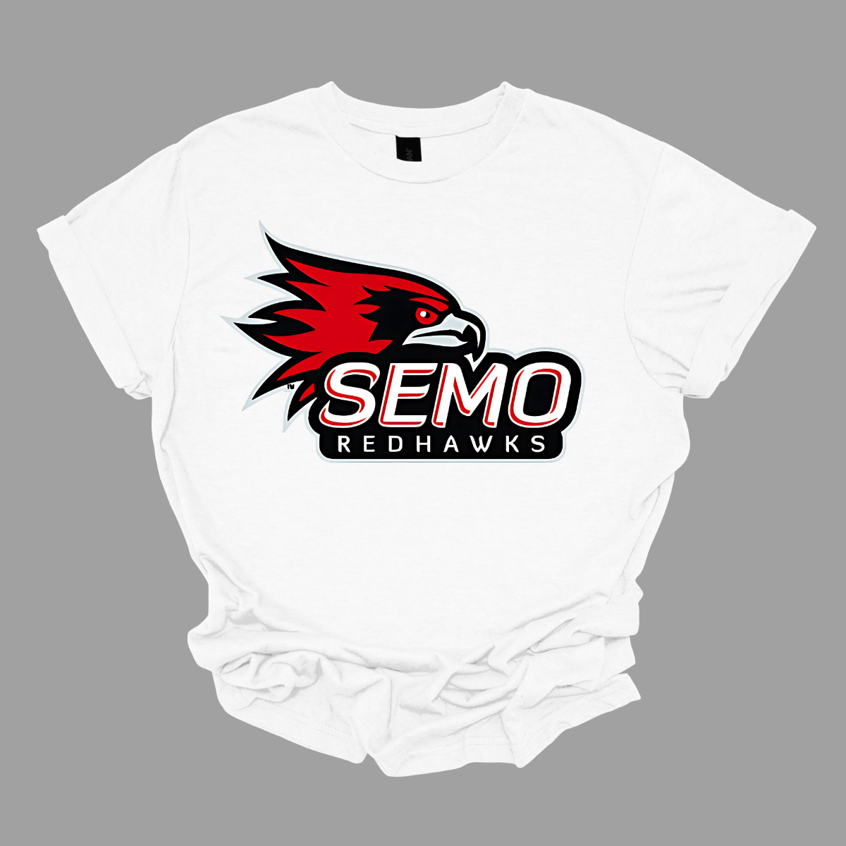 This vibrant t-shirt features the iconic SEMO Redhawk logo prominently displayed at the top, showcasing the fierce spirit of the team. Below the hawk, bold bubble letters spell out "SEMO," creating a playful and eye-catching design. Just underneath, in smaller, stylish print, the word "Redhawks" completes the look, making it a perfect blend of fun and team pride.  Shop at Gorgeousware.com