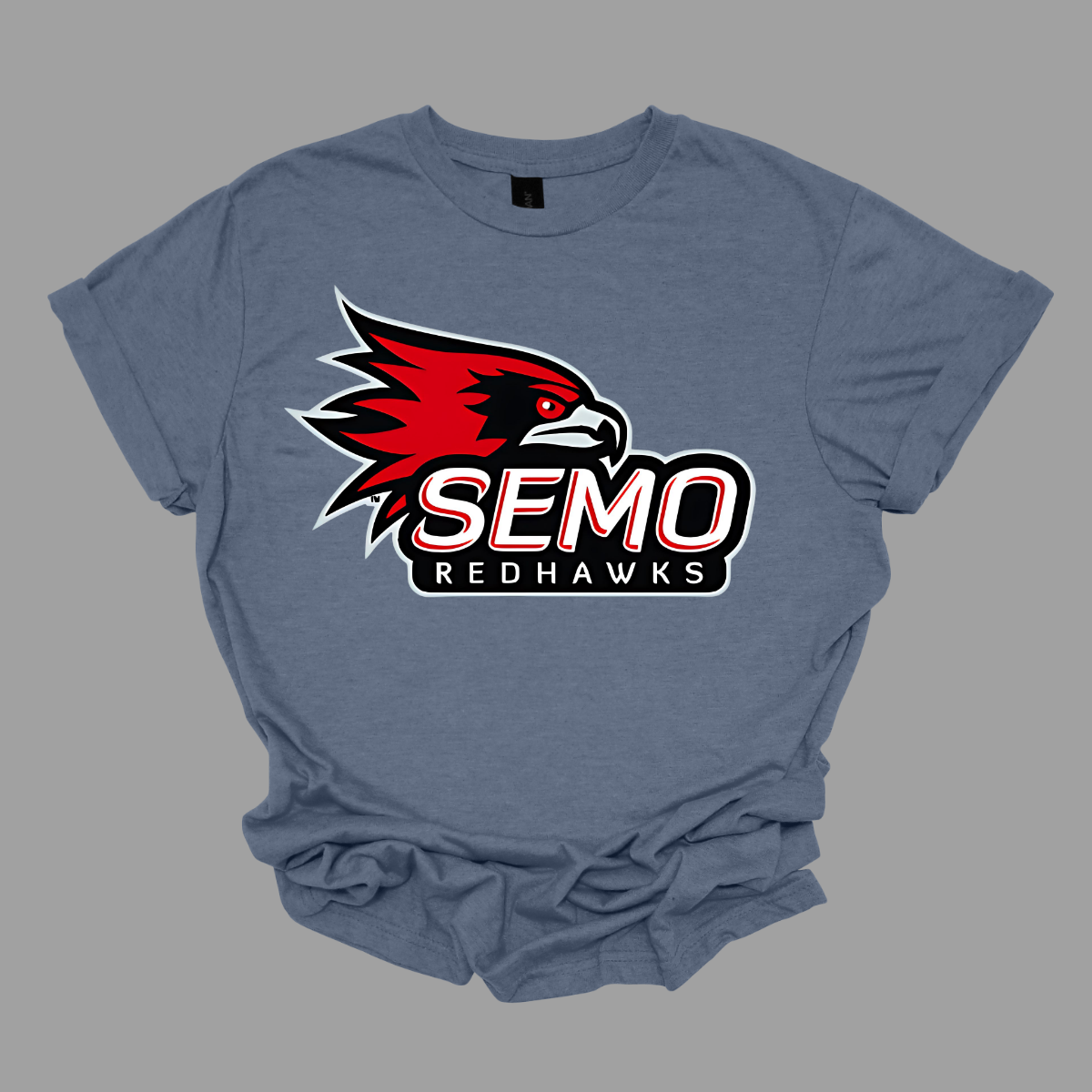 This vibrant t-shirt features the iconic SEMO Redhawk logo prominently displayed at the top, showcasing the fierce spirit of the team. Below the hawk, bold bubble letters spell out "SEMO," creating a playful and eye-catching design. Just underneath, in smaller, stylish print, the word "Redhawks" completes the look, making it a perfect blend of fun and team pride.  Shop at Gorgeousware.com