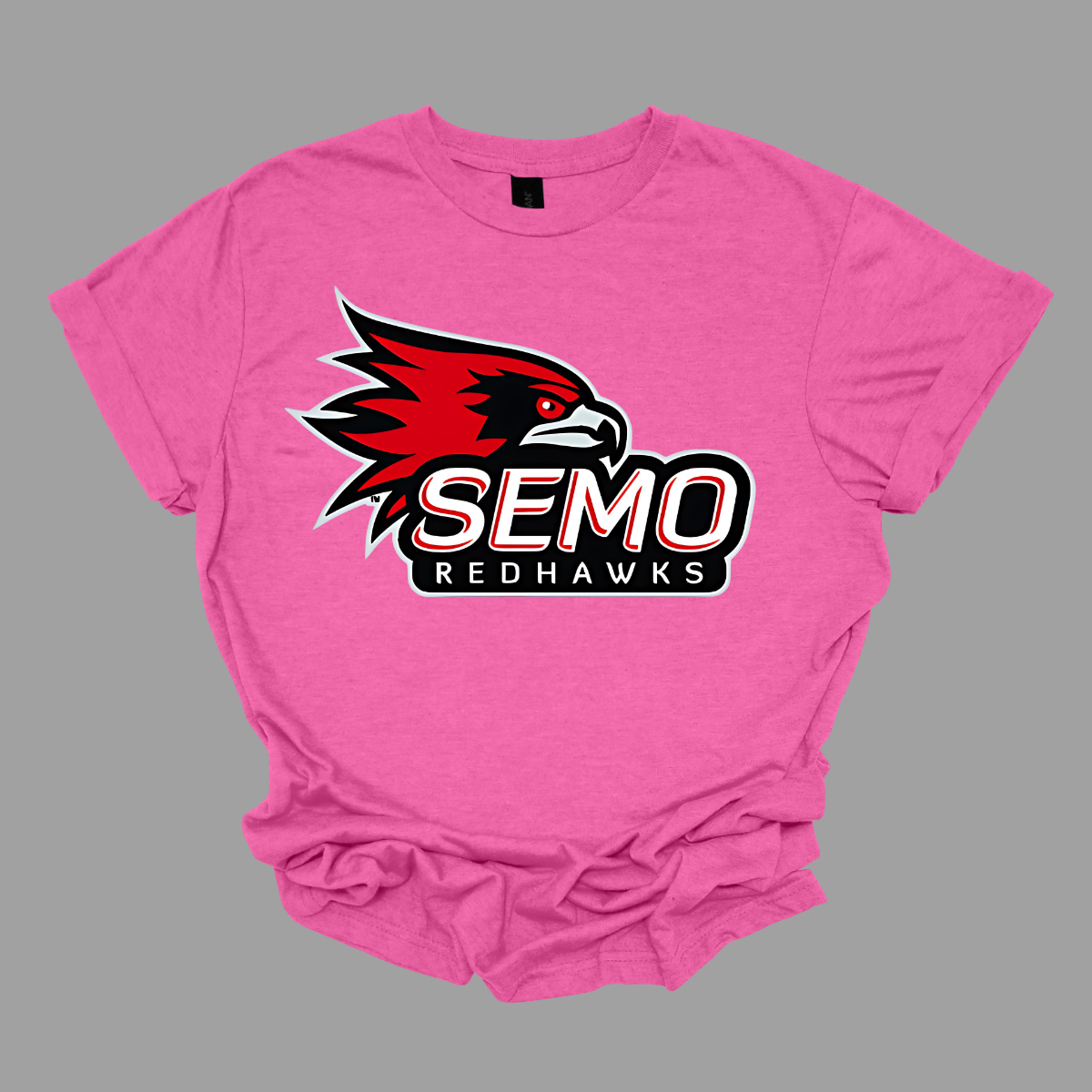 This vibrant t-shirt features the iconic SEMO Redhawk logo prominently displayed at the top, showcasing the fierce spirit of the team. Below the hawk, bold bubble letters spell out "SEMO," creating a playful and eye-catching design. Just underneath, in smaller, stylish print, the word "Redhawks" completes the look, making it a perfect blend of fun and team pride. Shop at Gorgeousware.com