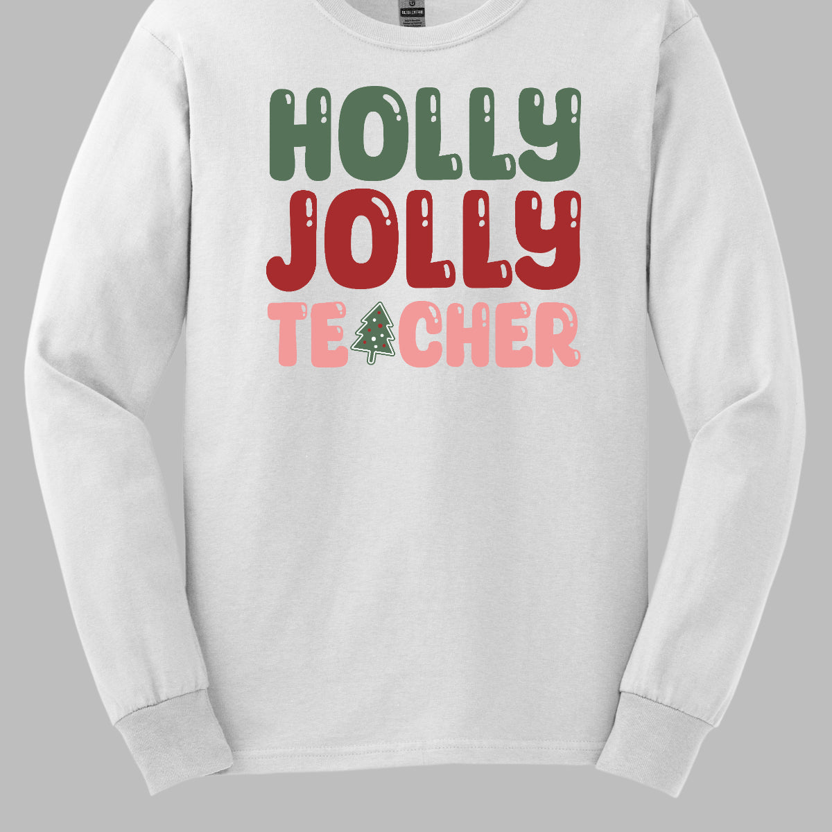 This festive t-shirt features the cheerful phrase "Holly Jolly Teacher" in a delightful bubbly font with fun cut-outs that add a playful touch. The word "Holly" is presented in a vibrant green, evoking the essence of holiday greenery, while "Jolly" pops in a bright red, radiating festive cheer. The word "Teacher" is in a cheerful pink, providing a lovely contrast. A whimsical twist comes with the letter "A" in "Teacher," which is creatively transformed into a charming Christmas tree. Shop Gorgeousware.com