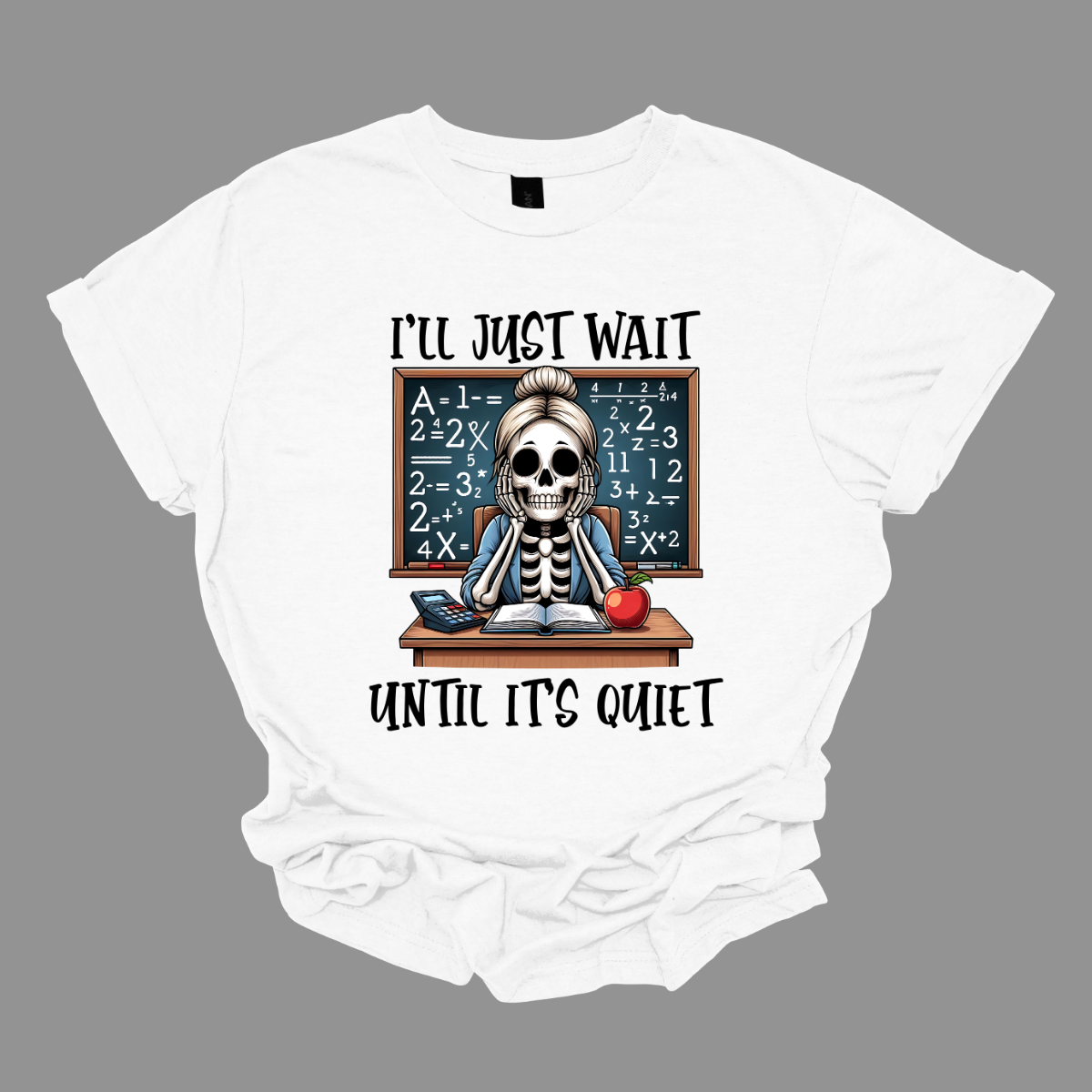 This T-shirt features a skeleton sitting at a cluttered desk, dressed in a cozy cardigan with a messy bun on top of its skull. The skeleton is leaning forward, resting its head on its bony hands as if exhausted or overwhelmed.  The shirt says, "I'll just wait until its quiet".  Shop at Gorgeousware.com