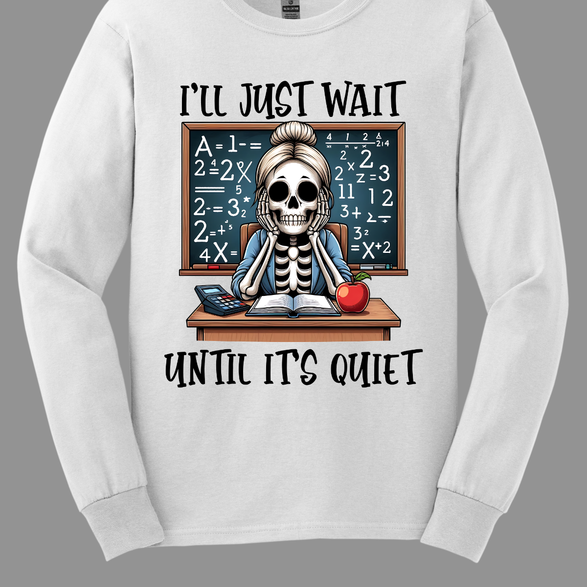 This T-shirt features a skeleton sitting at a cluttered desk, dressed in a cozy cardigan with a messy bun on top of its skull. The skeleton is leaning forward, resting its head on its bony hands as if exhausted or overwhelmed. The shirt says, "I'll just wait until its quiet". Shop at Gorgeousware.com