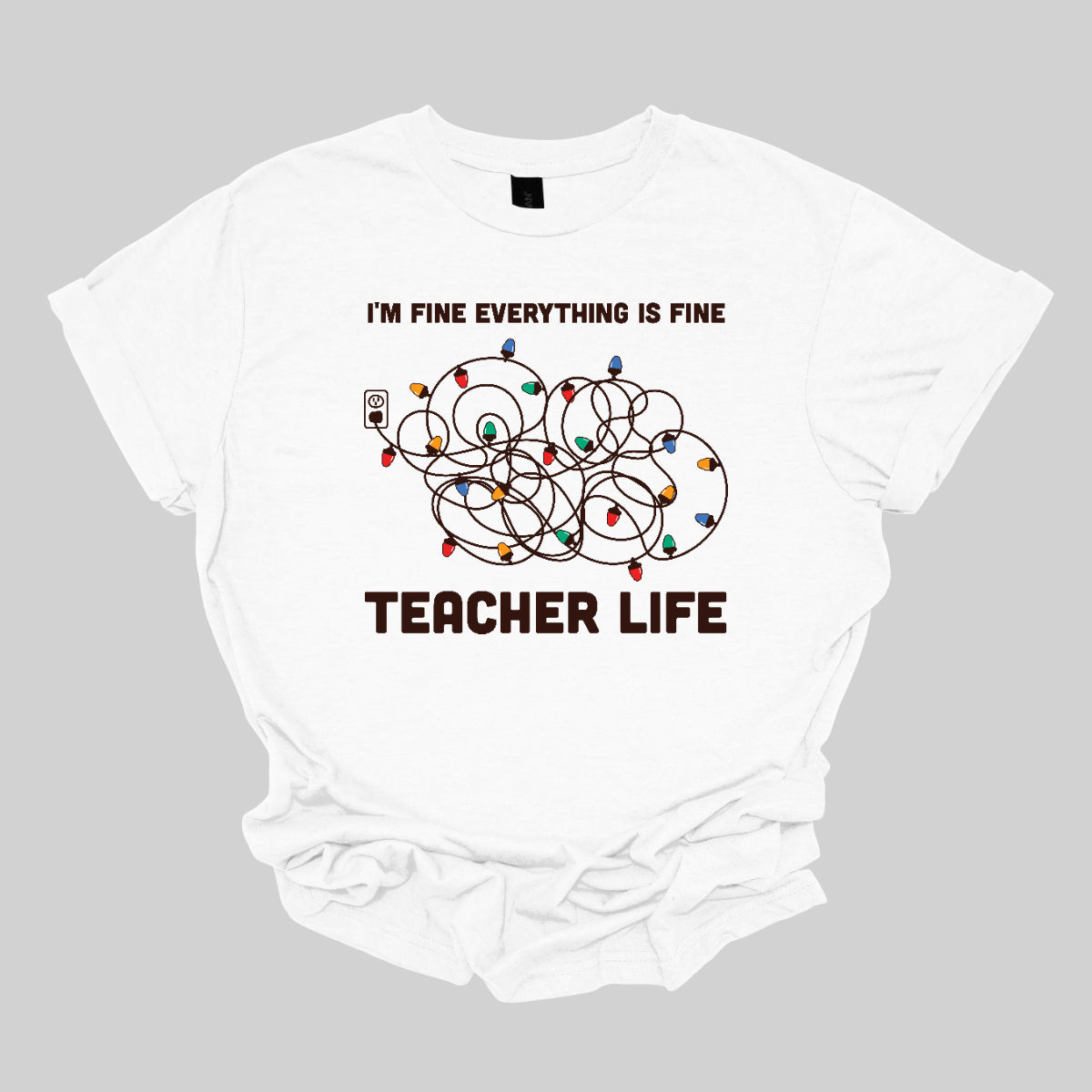 This humorous t-shirt features the phrase "I'm fine, everything is fine" in bold, playful lettering, perfectly capturing that relatable holiday vibe. Below the text, there's a whimsical illustration of a tangled wad of Christmas lights plugged into an outlet, humorously representing the chaos that can come with the season. Underneath the lights, the words "Teacher Life" are displayed, adding a clever nod to the unique challenges teachers face, especially during the festive rush. Shop at Gorgeousware.com