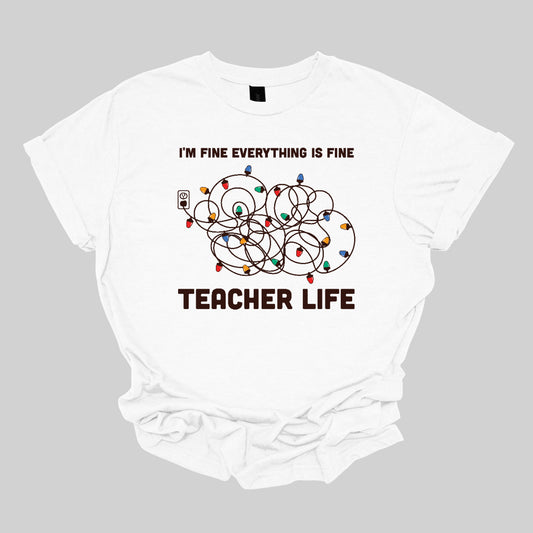 This humorous t-shirt features the phrase "I'm fine, everything is fine" in bold, playful lettering, perfectly capturing that relatable holiday vibe. Below the text, there's a whimsical illustration of a tangled wad of Christmas lights plugged into an outlet, humorously representing the chaos that can come with the season. Underneath the lights, the words "Teacher Life" are displayed, adding a clever nod to the unique challenges teachers face, especially during the festive rush. Shop at Gorgeousware.com