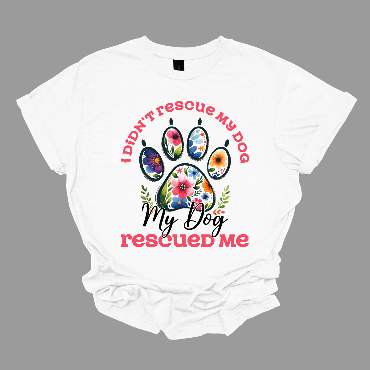 This shirt features a heartwarming and empowering message that says, "I didn't rescue my dog, my dog rescued me." The design centers around a large, bold paw print, with the pads of the paw beautifully adorned with intricate floral details. The combination of pink and black lettering gives the design a stylish and vibrant contrast. Shop Gorgeouseware.com
