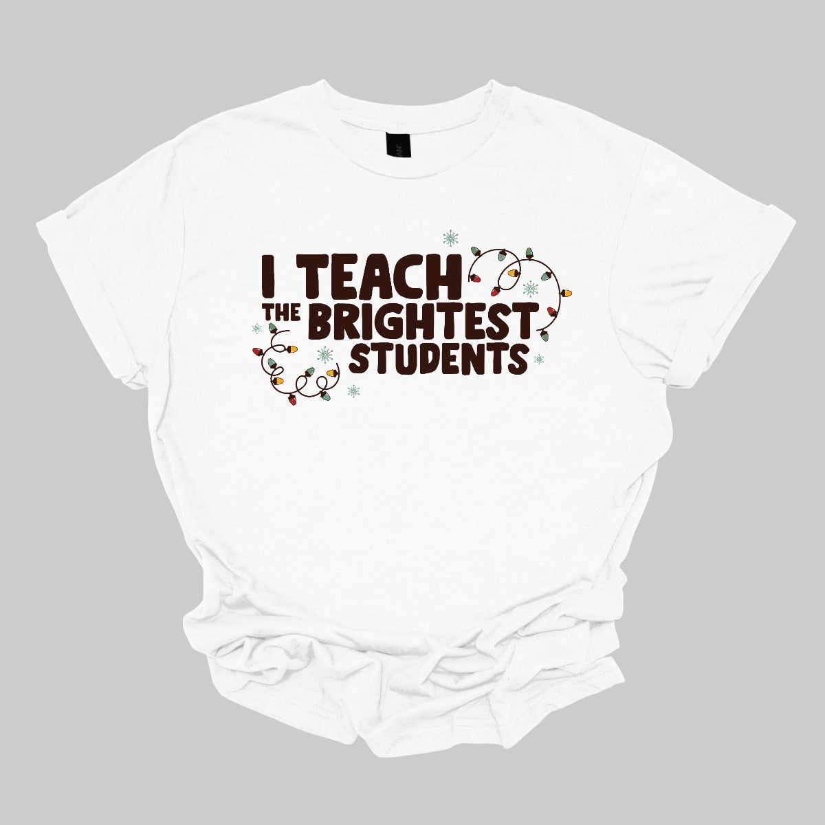 Celebrate your passion for teaching with our "I Teach the Brightest Students" t-shirt! This fun and festive design features cheerful Christmas lights framing the text, adding a touch of holiday spirit to your classroom vibe. Made from soft, comfortable fabric, it’s perfect for wearing during the festive season or any day you want to show off your pride in your students. Brighten up your wardrobe and spread some joy—because every great teacher deserves to