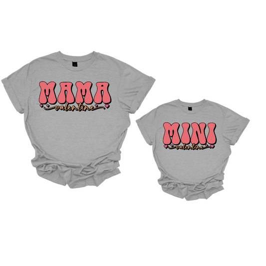 Share the love with our 'Mama Valentine' and 'Mini Valentine' matching T-shirts, adorned with a cascade of adorable little hearts. Crafted for comfort and sweetness, these coordinated tees are the perfect way for mother and child to express their love in style. The charming hearts add a touch of whimsy to the design, creating a delightful ensemble for Valentine's Day or any special occasion.
