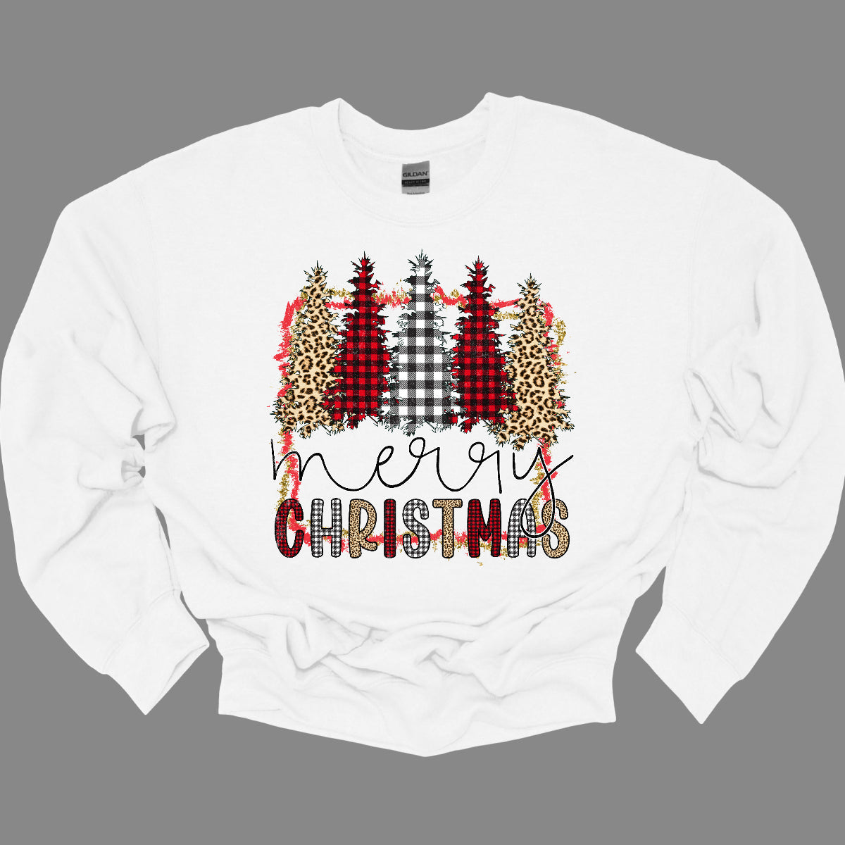 This festive t-shirt showcases the playful phrase "Merry Christmas." The word "Merry" is elegantly rendered in a fine line black cursive, giving it a classic touch. Below, "Christmas" features a lively bubbly font that alternates between red and black plaid, white and black plaid, and cheetah print, adding a fun and trendy vibe. Shop Gorgeousware.com