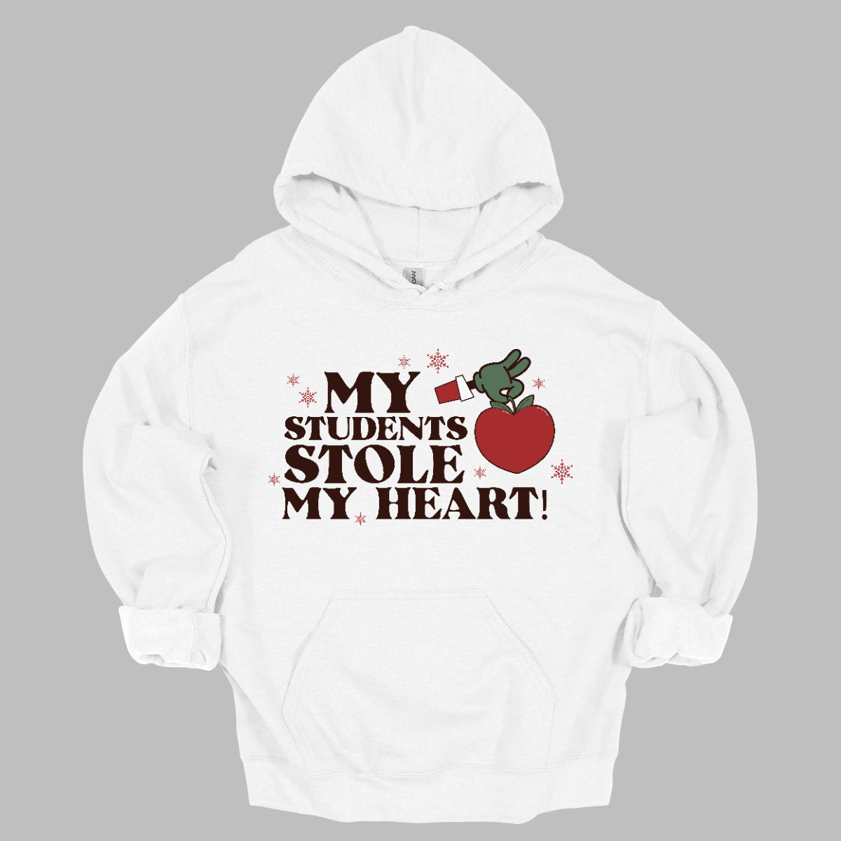 This playful t-shirt features the phrase "My students stole my heart" in fun, whimsical lettering that captures the spirit of teaching. Below the text, a cheeky illustration of the Grinch's green arm emerges, playfully grasping a shiny red apple, symbolizing knowledge and education. Shop at Gorgeousware.com