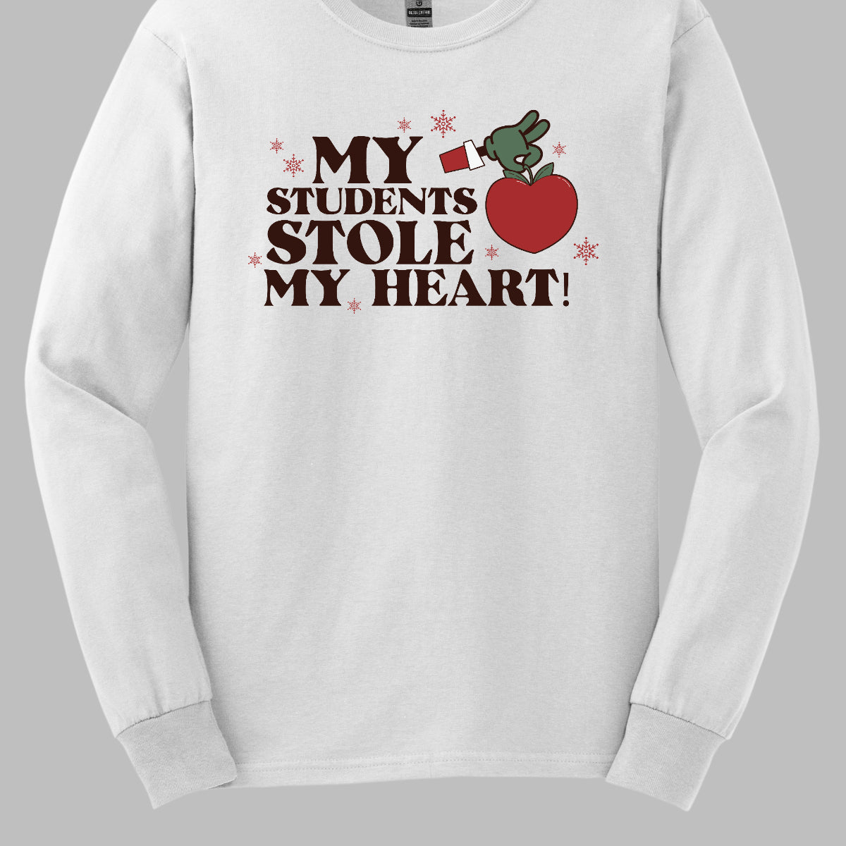 This playful t-shirt features the phrase "My students stole my heart" in fun, whimsical lettering that captures the spirit of teaching. Below the text, a cheeky illustration of the Grinch's green arm emerges, playfully grasping a shiny red apple, symbolizing knowledge and education. Shop at Gorgeousware.com