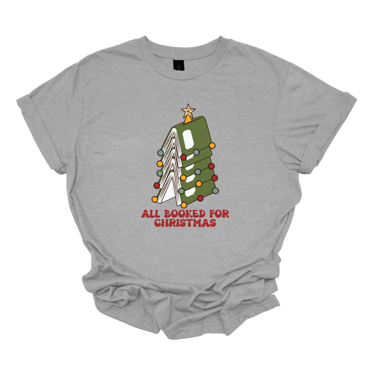 This whimsical t-shirt features the playful phrase "All Booked for Christmas" in a bold, red bubbly font that captures the festive spirit. Above the text, a delightful image showcases a stack of green books, artfully arranged to resemble a decorated Christmas tree. Shop Gorgeousware.com