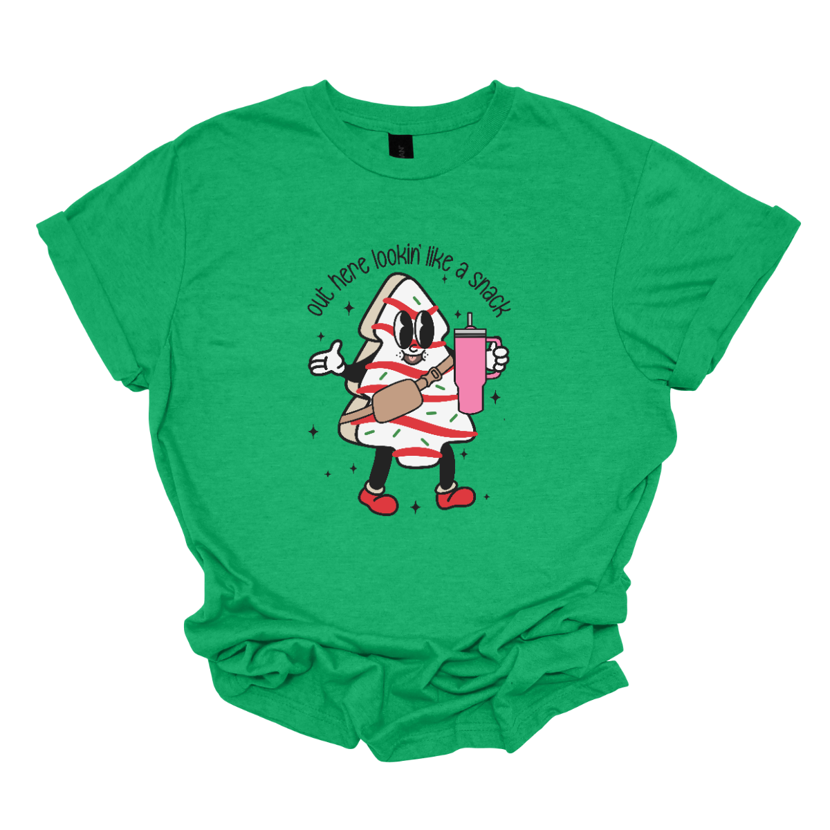 This playful t-shirt features the phrase "Out here lookin' like a snack" in a bold black stick figure font, giving it a fun and casual vibe. Beneath the text, a charming cartoon Christmas tree cake adds a whimsical touch, complete with a cheerful smiling face, a stylish belt bag, and a cup. The surrounding sparkles enhance the festive spirit, making this shirt a delightful choice for spreading holiday cheer with a humorous twist! Shop Gorgeousware.com