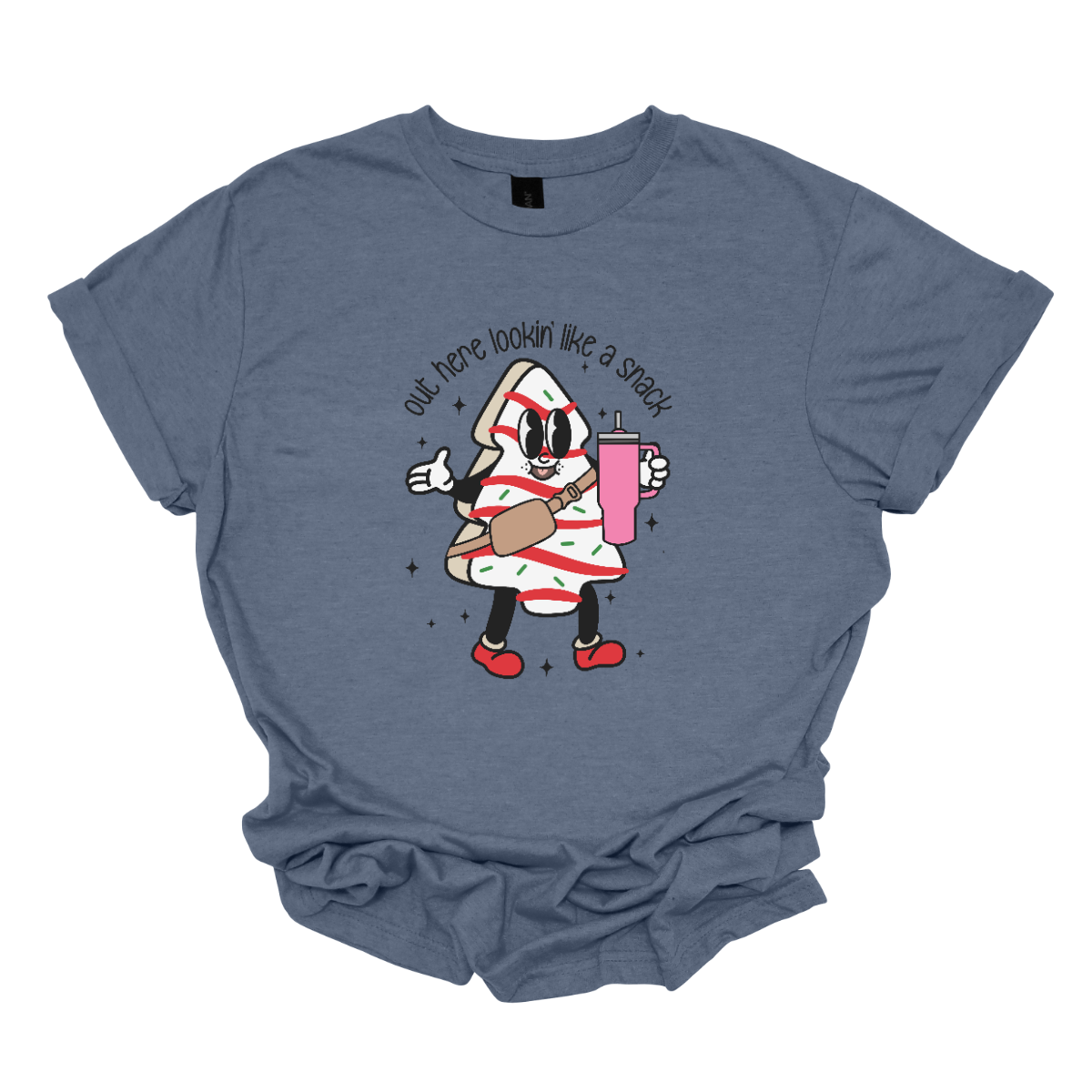 This playful t-shirt features the phrase "Out here lookin' like a snack" in a bold black stick figure font, giving it a fun and casual vibe. Beneath the text, a charming cartoon Christmas tree cake adds a whimsical touch, complete with a cheerful smiling face, a stylish belt bag, and a cup. The surrounding sparkles enhance the festive spirit, making this shirt a delightful choice for spreading holiday cheer with a humorous twist! Shop Gorgeousware.com