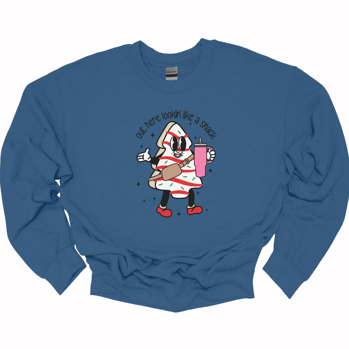 This playful t-shirt features the phrase "Out here lookin' like a snack" in a bold black stick figure font, giving it a fun and casual vibe. Beneath the text, a charming cartoon Christmas tree cake adds a whimsical touch, complete with a cheerful smiling face, a stylish belt bag, and a cup. The surrounding sparkles enhance the festive spirit, making this shirt a delightful choice for spreading holiday cheer with a humorous twist! Shop Gorgeousware.com