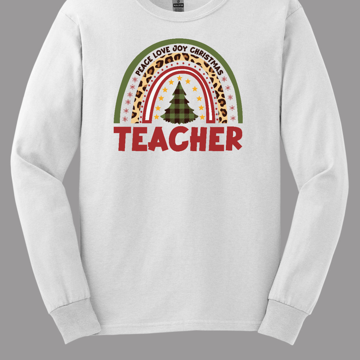 The t-shirt design features a vibrant, patterned rainbow that arcs gracefully across the fabric. Each color of the rainbow is adorned with playful patterns, such as polka dots, snowflakes, and cheetah print, adding a whimsical touch. At the center of the rainbow stands a beautifully illustrated Christmas tree. Shop at orgeousware.com
