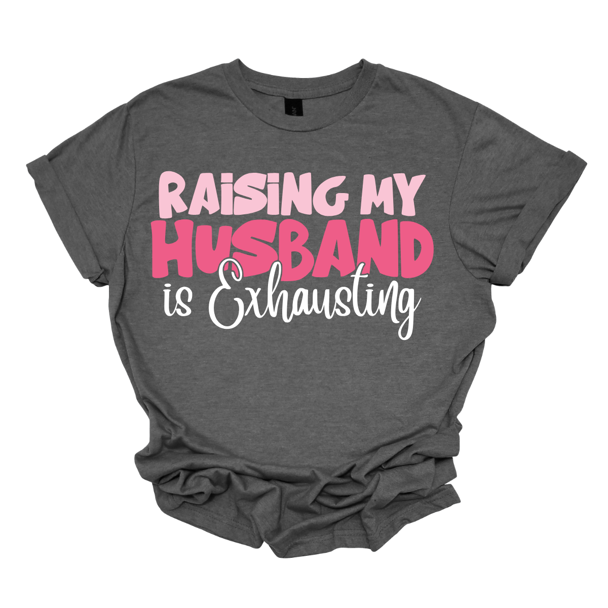 This T-shirt features the humorous phrase "Raising My Husband Is Exhausting" prominently across the chest. The text is creatively arranged in a mix of playful and quirky fonts, each each line standing out with a unique style. The color palette is a soft and vibrant pink, with a varying shade to enhance the fun and lighthearted vibe of the design. Shop at Gorgeousware.com