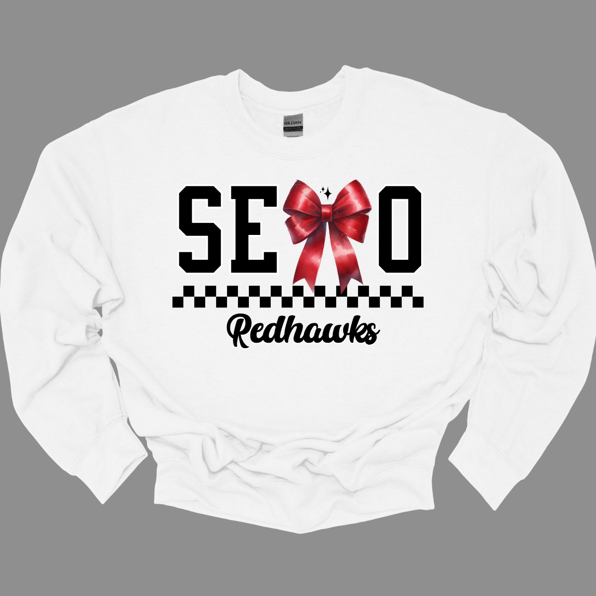 Show off your SEMO pride in style with this trendy apparel for youth! This shirt features bold letters” SEMO,” where the "M" is cleverly replaced by a stylish red croquette bow, this shirt adds a unique twist to your wardrobe. Underneath, a playful checkerboard stripe adds a fun touch, while "Redhawks" is elegantly written in a cute cursive font. Get ready to turn heads and express your school spirit! Shop at Gorgeousware.com today!