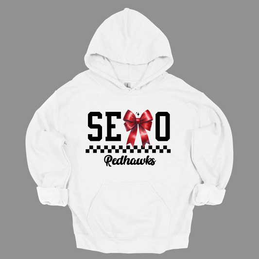 Show off your SEMO pride in style with this trendy apparel for youth! This shirt features bold letters” SEMO,” where the "M" is cleverly replaced by a stylish red croquette bow, this shirt adds a unique twist to your wardrobe. Underneath, a playful checkerboard stripe adds a fun touch, while "Redhawks" is elegantly written in a cute cursive font. Get ready to turn heads and express your school spirit! Shop at Gorgeousware.com today!