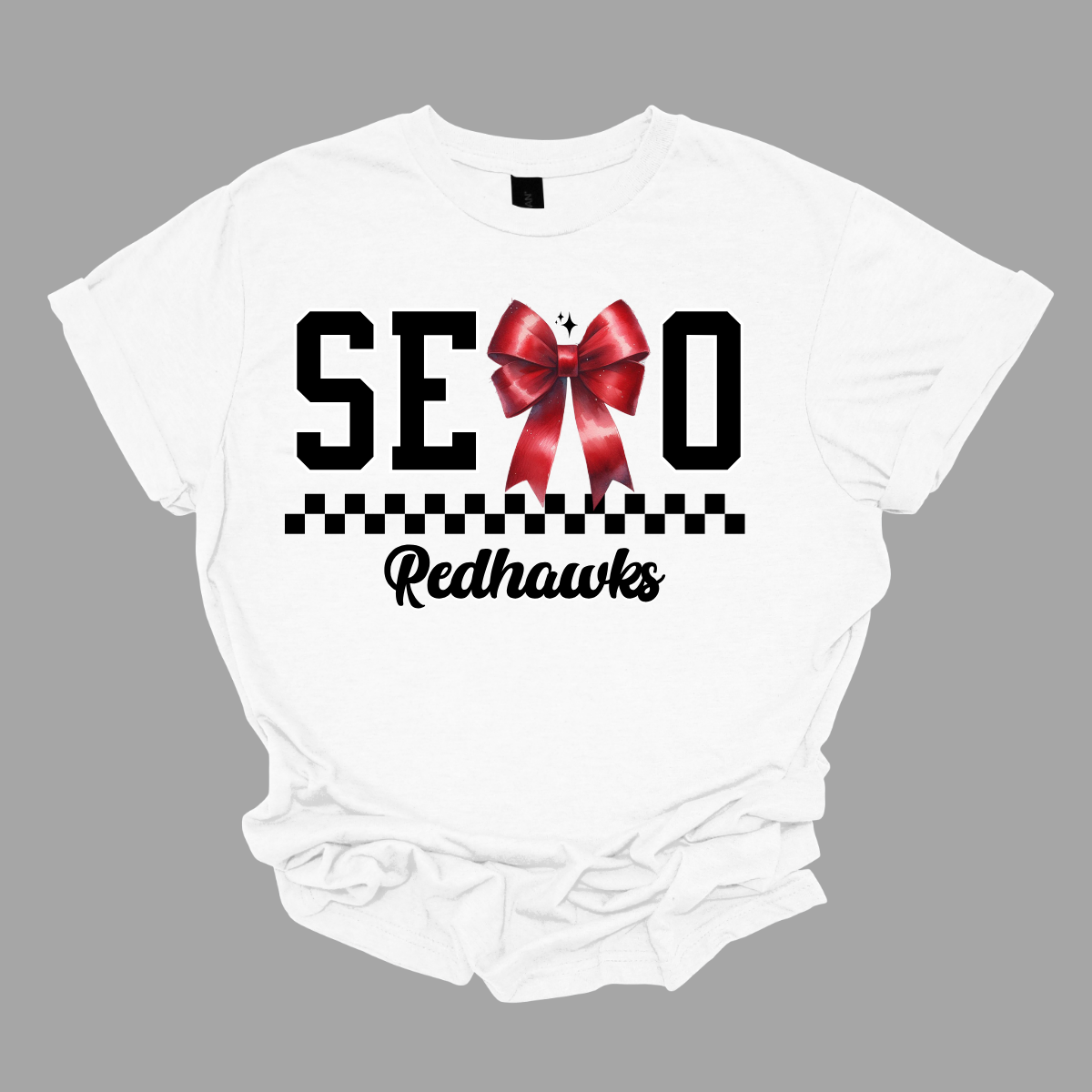 Show off your SEMO pride in style with this trendy apparel for youth! This shirt features bold letters” SEMO,” where the "M" is cleverly replaced by a stylish red croquette bow, this shirt adds a unique twist to your wardrobe. Underneath, a playful checkerboard stripe adds a fun touch, while "Redhawks" is elegantly written in a cute cursive font. Get ready to turn heads and express your school spirit! Shop at Gorgeousware.com today!