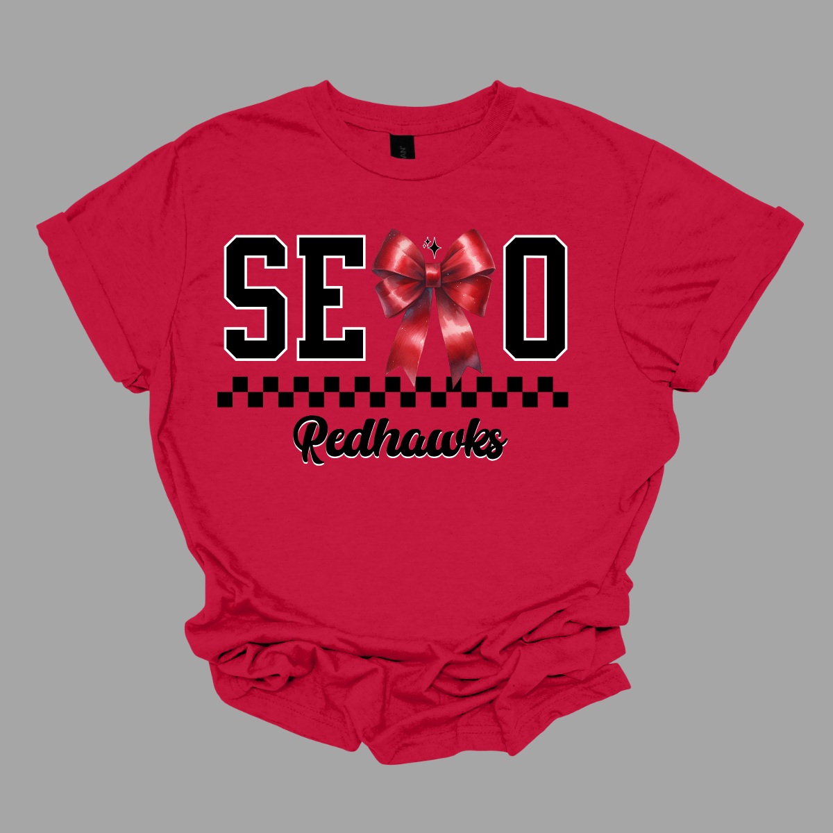 Show off your SEMO pride in style with this trendy apparel for youth! This shirt features bold letters” SEMO,” where the "M" is cleverly replaced by a stylish red croquette bow, this shirt adds a unique twist to your wardrobe. Underneath, a playful checkerboard stripe adds a fun touch, while "Redhawks" is elegantly written in a cute cursive font. Get ready to turn heads and express your school spirit! Shop at Gorgeousware.com today!