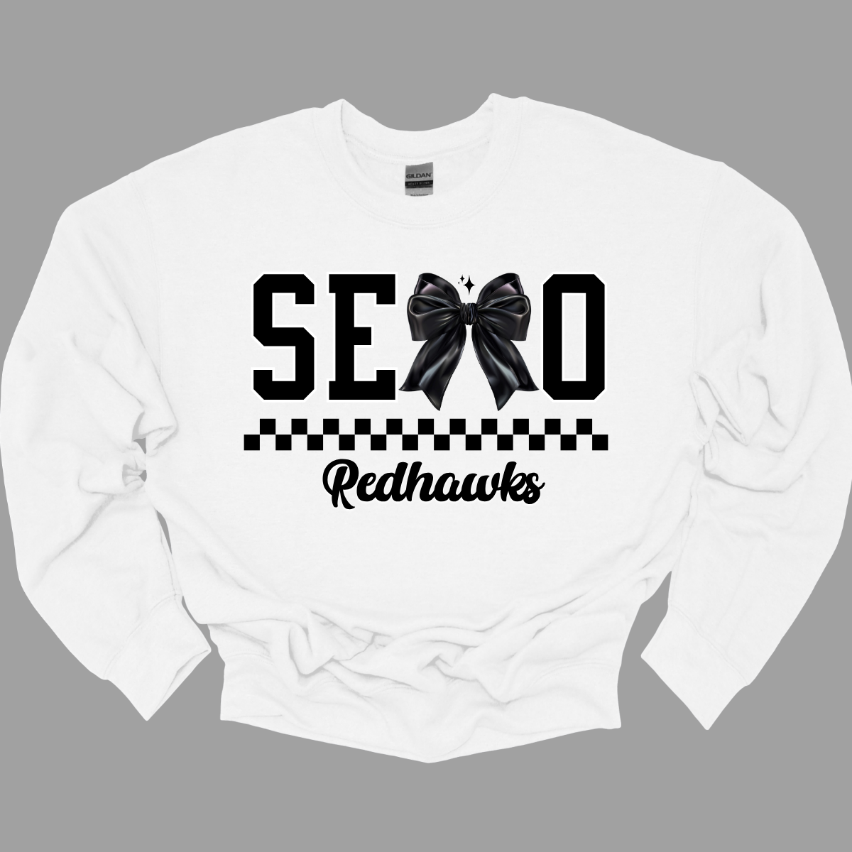 Show off your SEMO pride in style with this trendy creneck and hoodie! Featuring the bold letters "SEMO," where the "M" is cleverly replaced by a stylish black croquette bow, this shirt adds a unique twist to your wardrobe. Underneath, a playful checkerboard stripe adds a fun touch, while "Redhawks" is elegantly written in a cute cursive font, bringing a touch of flair. Shop at Gorgeousware.com