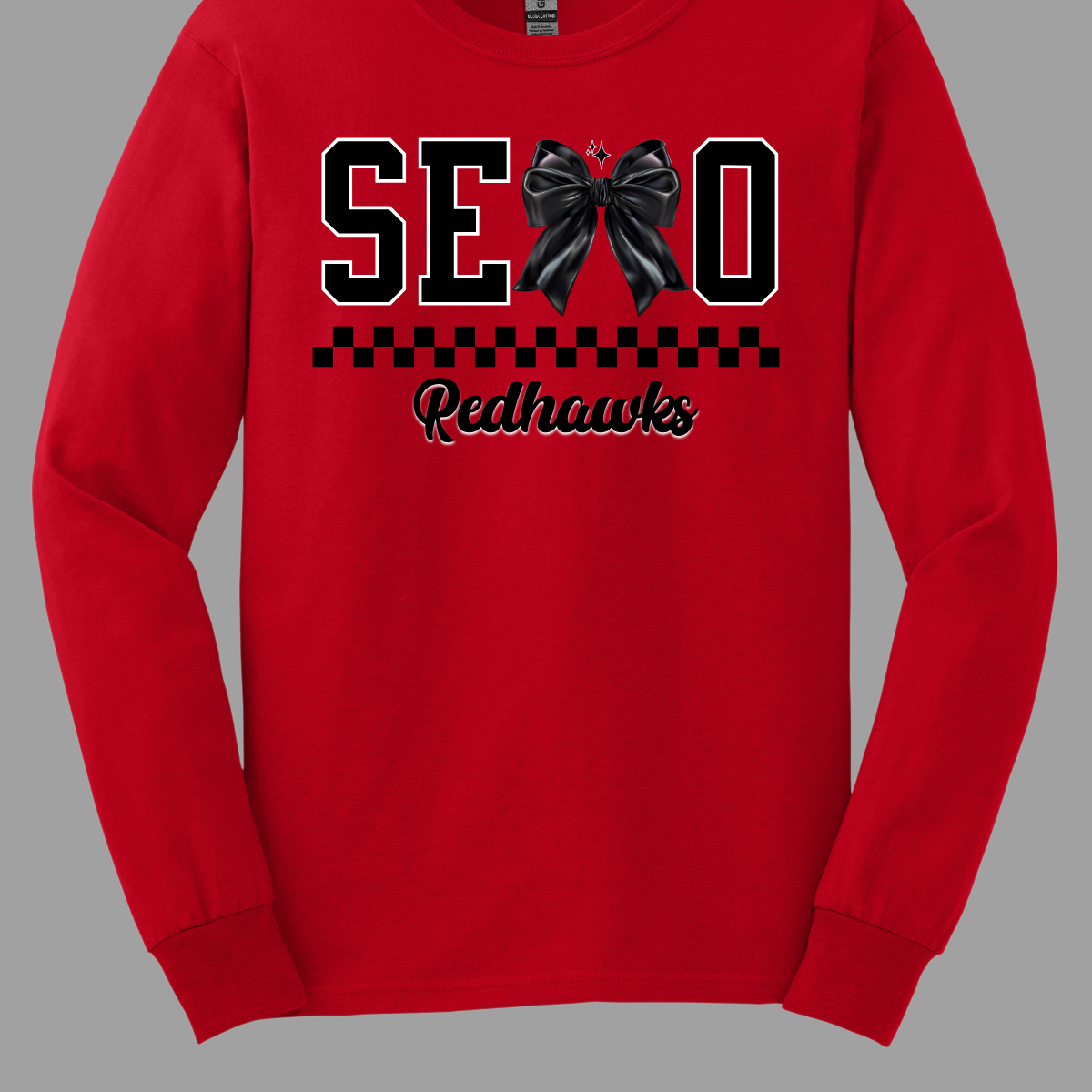 Show off your SEMO pride in style with this trendy short sleeve t-shirt! Featuring the bold letters "SEMO," where the "M" is cleverly replaced by a stylish black croquette bow, this shirt adds a unique twist to your wardrobe. Underneath, a playful checkerboard stripe adds a fun touch, while "Redhawks" is elegantly written in a cute cursive font, bringing a touch of flair. Shop at Gorgeousware.com