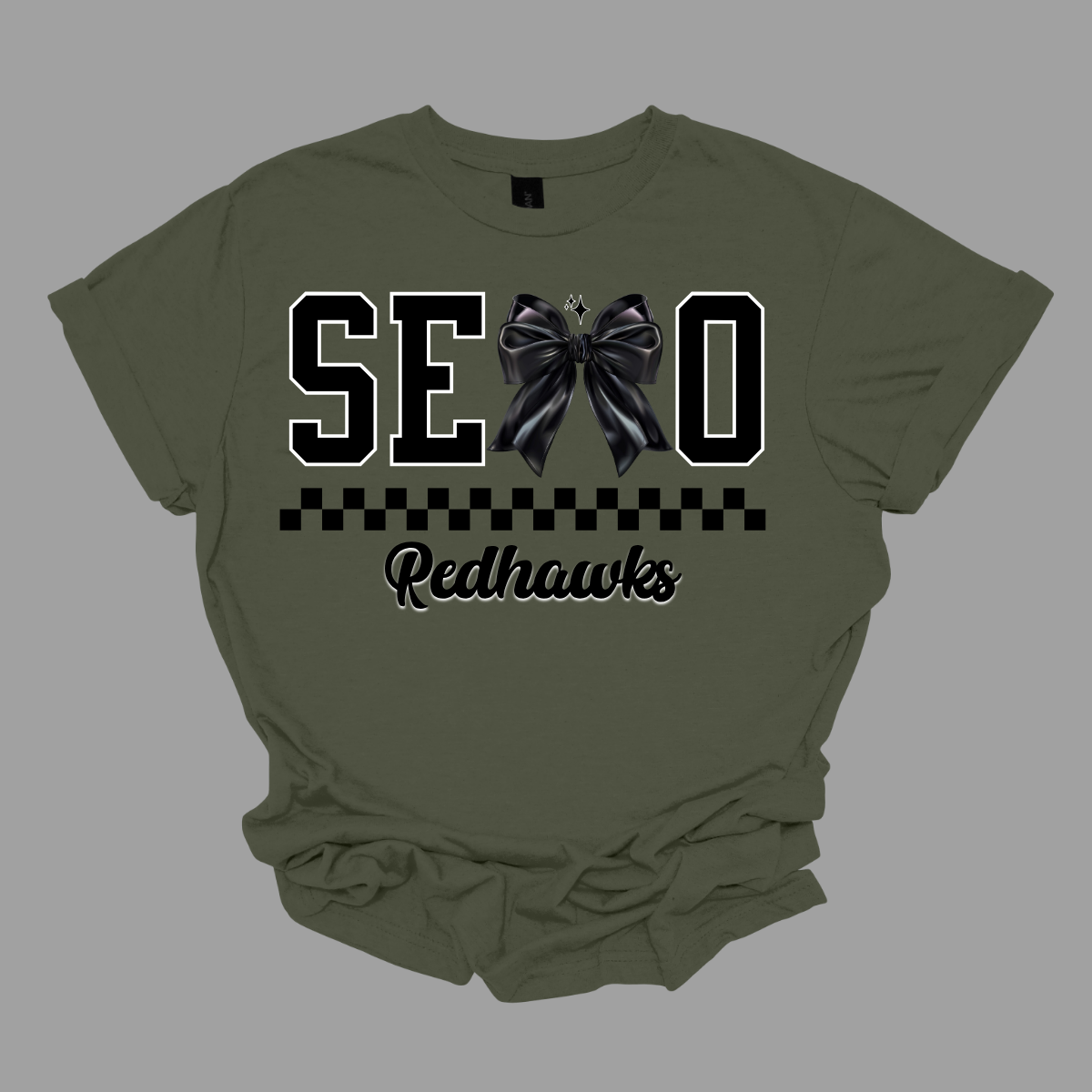 Show off your SEMO pride in style with this trendy short sleeve t-shirt! Featuring the bold letters "SEMO," where the "M" is cleverly replaced by a stylish black croquette bow, this shirt adds a unique twist to your wardrobe. Underneath, a playful checkerboard stripe adds a fun touch, while "Redhawks" is elegantly written in a cute cursive font, bringing a touch of flair. Shop at Gorgeousware.com