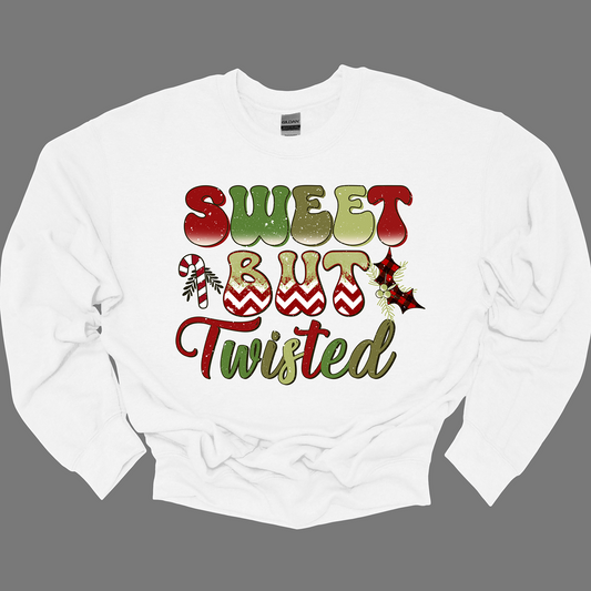 The apparel features a playful and bold design with the phrase "Sweet but Twisted" prominently displayed in large bubble letters. The letters are vibrant, with shades of green and red, creating a fun, festive contrast. The word "but" stands out, with its bottom edges filled with a red and white chevron pattern, adding a striking visual detail. Shop at Gorgeousware.com