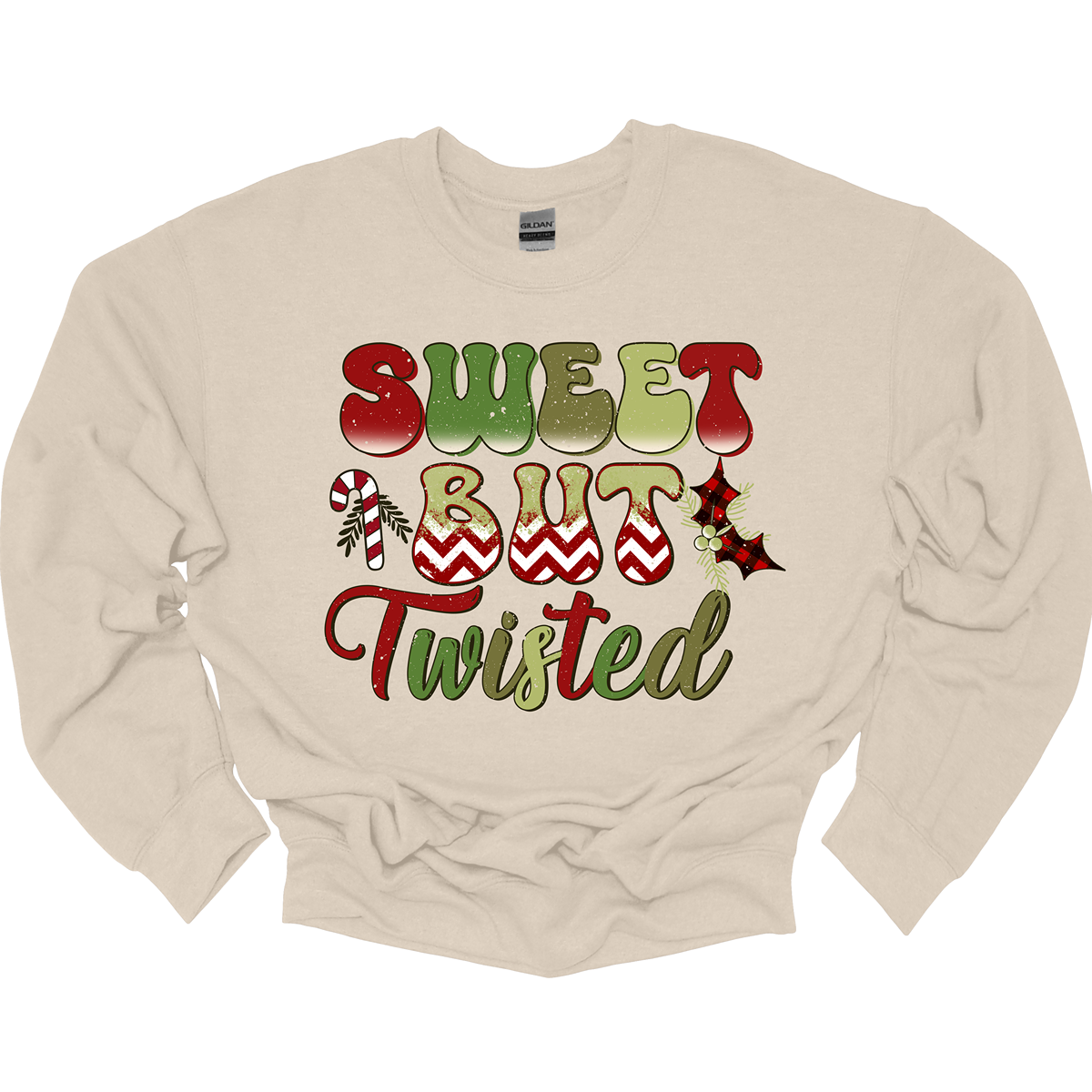 The apparel features a playful and bold design with the phrase "Sweet but Twisted" prominently displayed in large bubble letters. The letters are vibrant, with shades of green and red, creating a fun, festive contrast. The word "but" stands out, with its bottom edges filled with a red and white chevron pattern, adding a striking visual detail. Shop at Gorgeousware.com