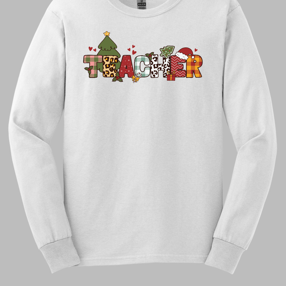This eye-catching t-shirt boldly displays the word "TEACHER" in large block letters, each letter showcasing a unique style of print that adds a fun and creative flair. Behind the first "E," a cheerful Christmas tree adds a festive touch, while the second "E" is adorned with a cute Santa hat, making it even more playful. Shop Gorgeouswre.com