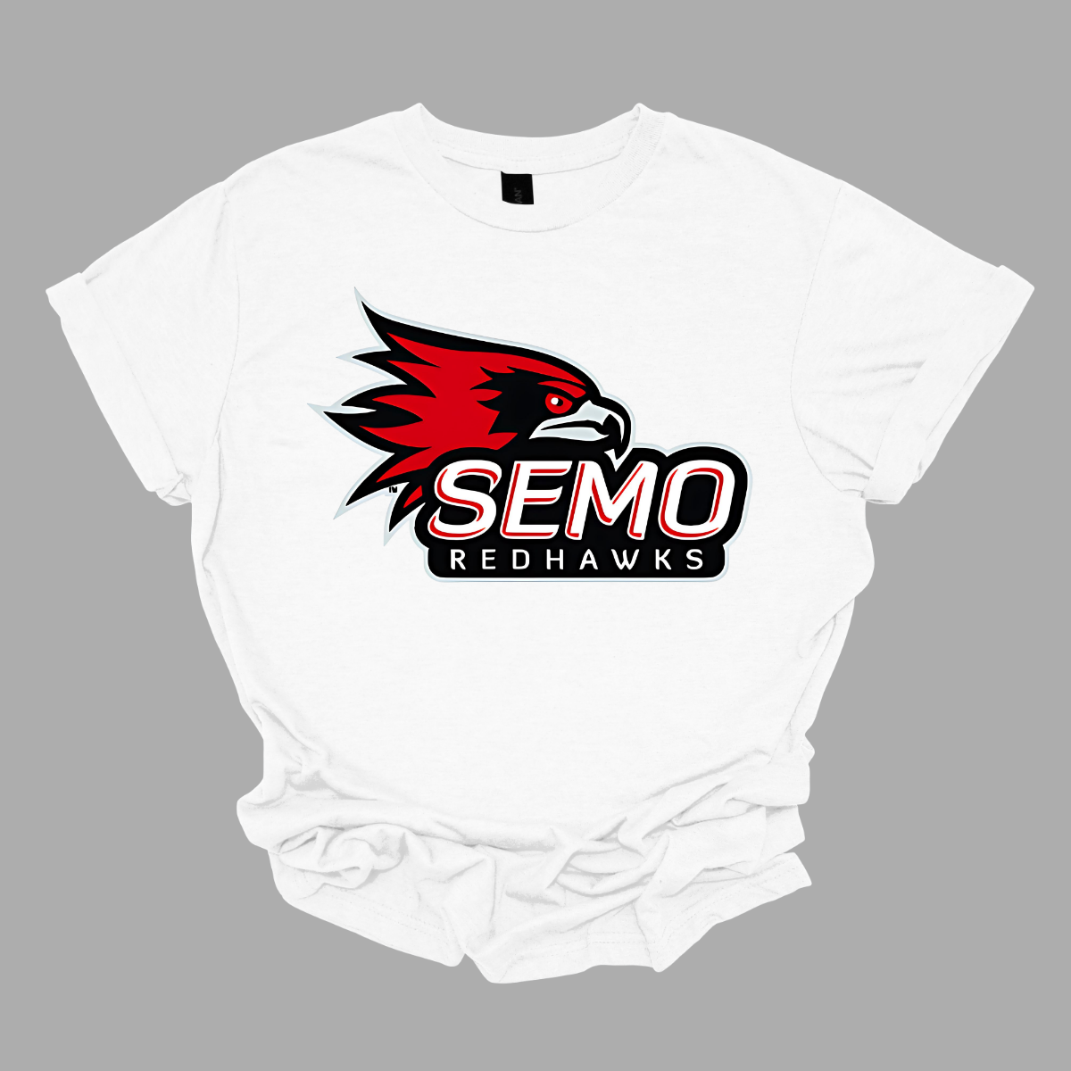 This vibrant t-shirt features the iconic SEMO Redhawk logo prominently displayed at the top, showcasing the fierce spirit of the team. Below the hawk, bold bubble letters spell out "SEMO," creating a playful and eye-catching design. Just underneath, in smaller, stylish print, the word "Redhawks" completes the look, making it a perfect blend of fun and team pride. Shop at Gorgeousware.com