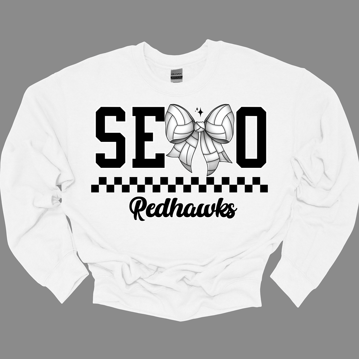 The apparel design features the word "SEMO" in a bold collegiate font, with a unique twist on the letter "M." Instead of the standard "M," a bow with a volleyball pattern is used, making it a distinctive and sporty element. Beneath "SEMO," a striking black checkerboard pattern runs horizontally across the garment, adding visual contrast and energy. hop at Gorgeousware.com