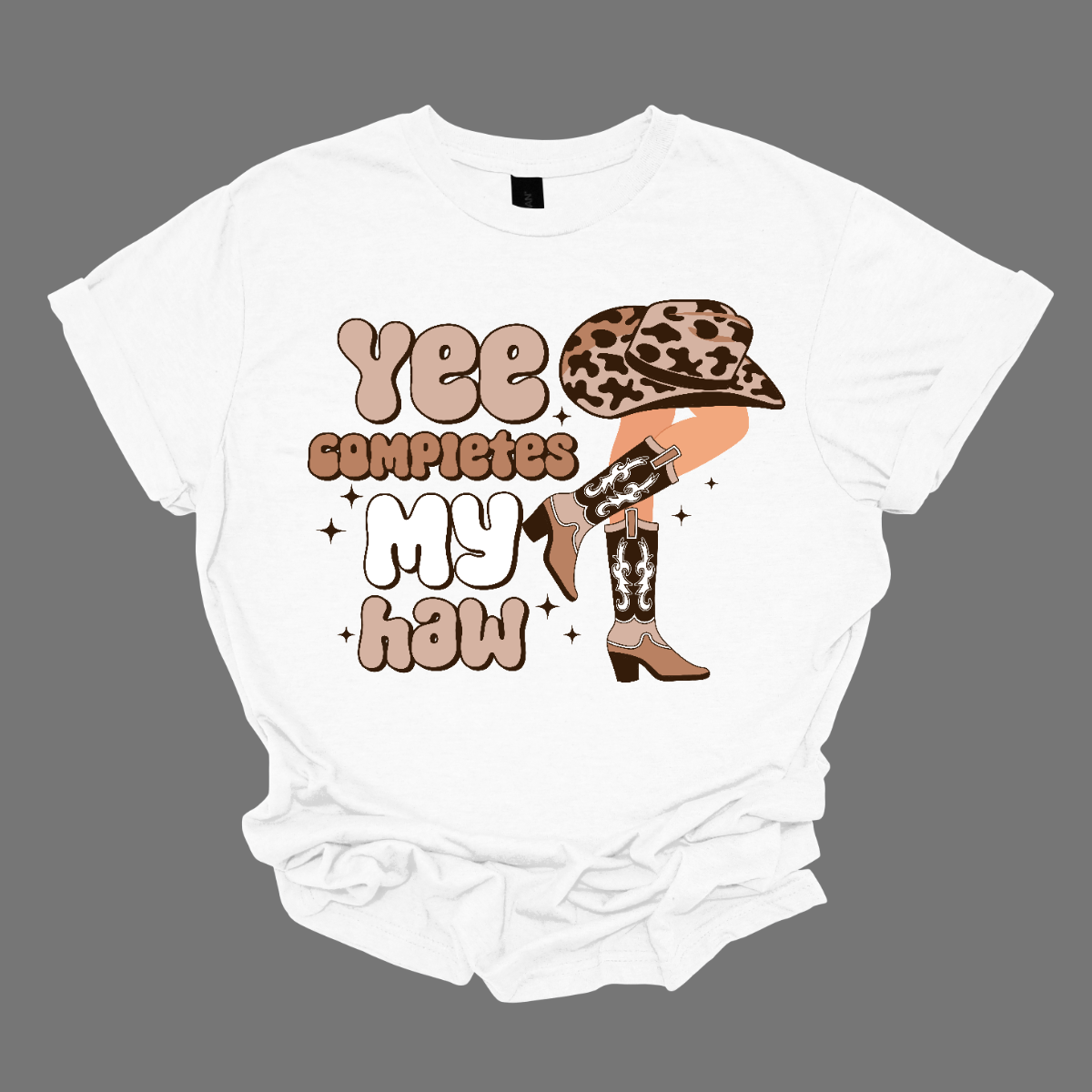 Introducing our "Yee Completes My Haw" T-shirt – a playful and charming garment that adds a touch of Western humor to your wardrobe. This shirt features the phrase "Yee Completes My Haw" accompanied by a whimsical illustration of a cowgirl leg kicked back, adorned with boots and a hat. Shop at Gorgeousware.com