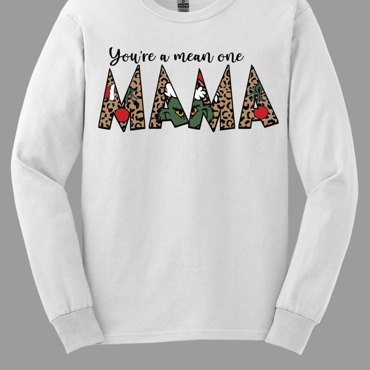 The phrase "You're a Mean One Mama" takes center stage, with "You're a Mean One" written in elegant black cursive font that flows beautifully across the fabric. The standout element is the word "Mama," which is rendered in bold, eye-catching letters. Each letter of "Mama" is filled with a quirky depiction of the Grinch, set against a vibrant cheetah print background. Shop Gorgeousware.com
